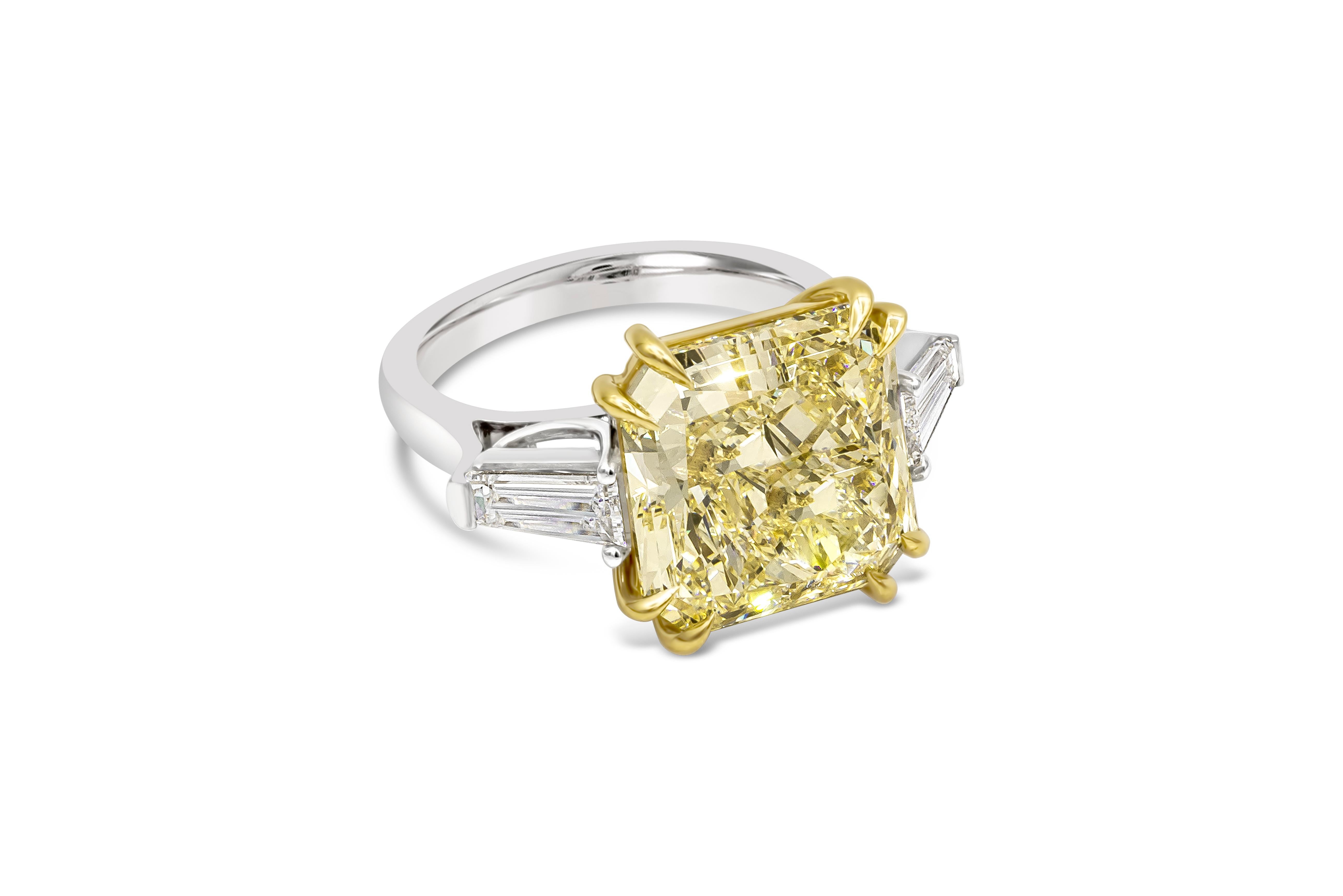 Elegantly made three stone engagement ring showcasing a color rich 10.11 carat radiant cut diamond certified by GIA as fancy light yellow, SI1 clarity, set in a eight prong 18k yellow gold basket. Flanking the center stone are tapered baguette side