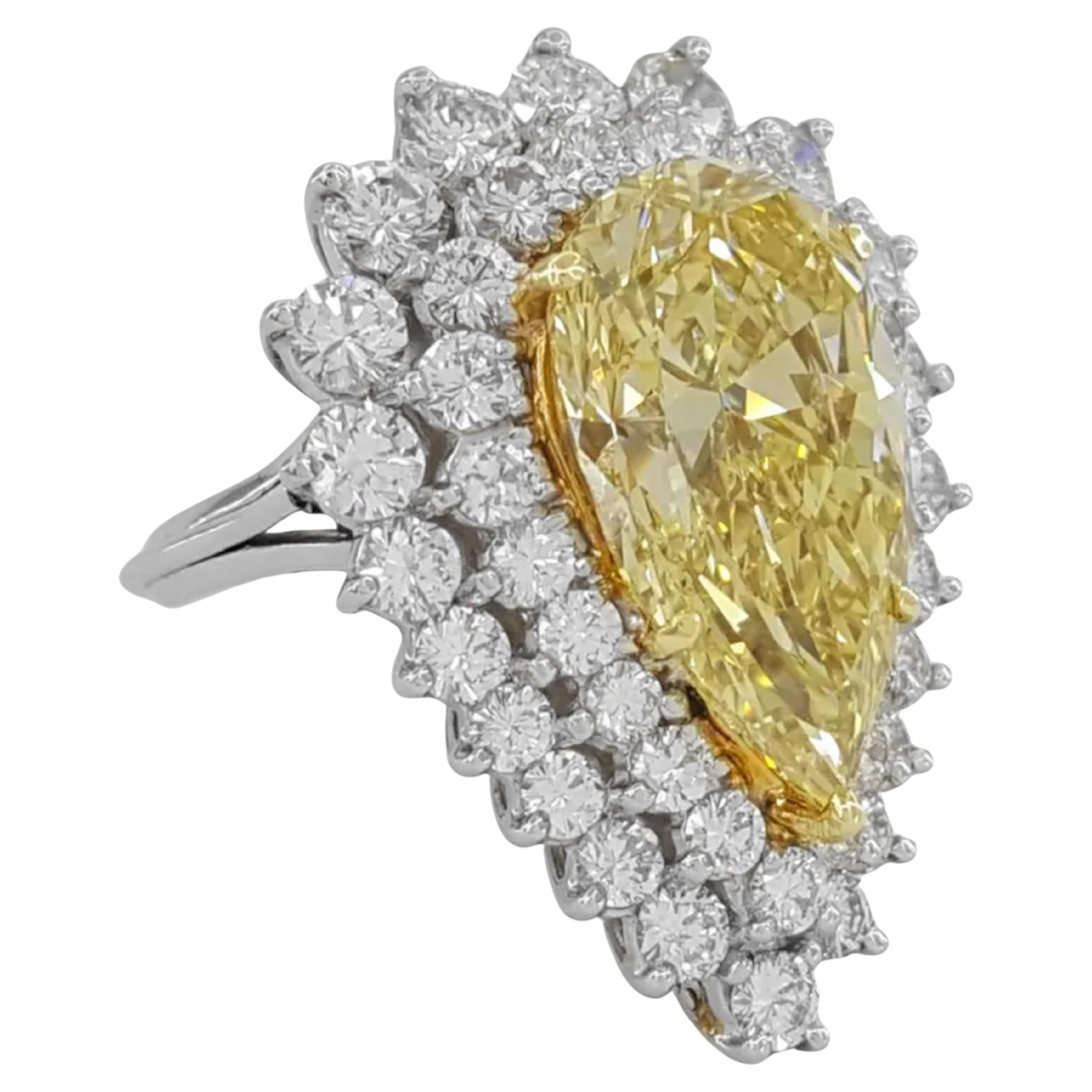 10 ct total weight pear brilliant cut natural fancy yellow diamond double halo engagement ring features a striking design in platinum and 18K yellow gold. The centerpiece is a 6.63 ct natural pear brilliant cut diamond, exhibiting a fancy brownish