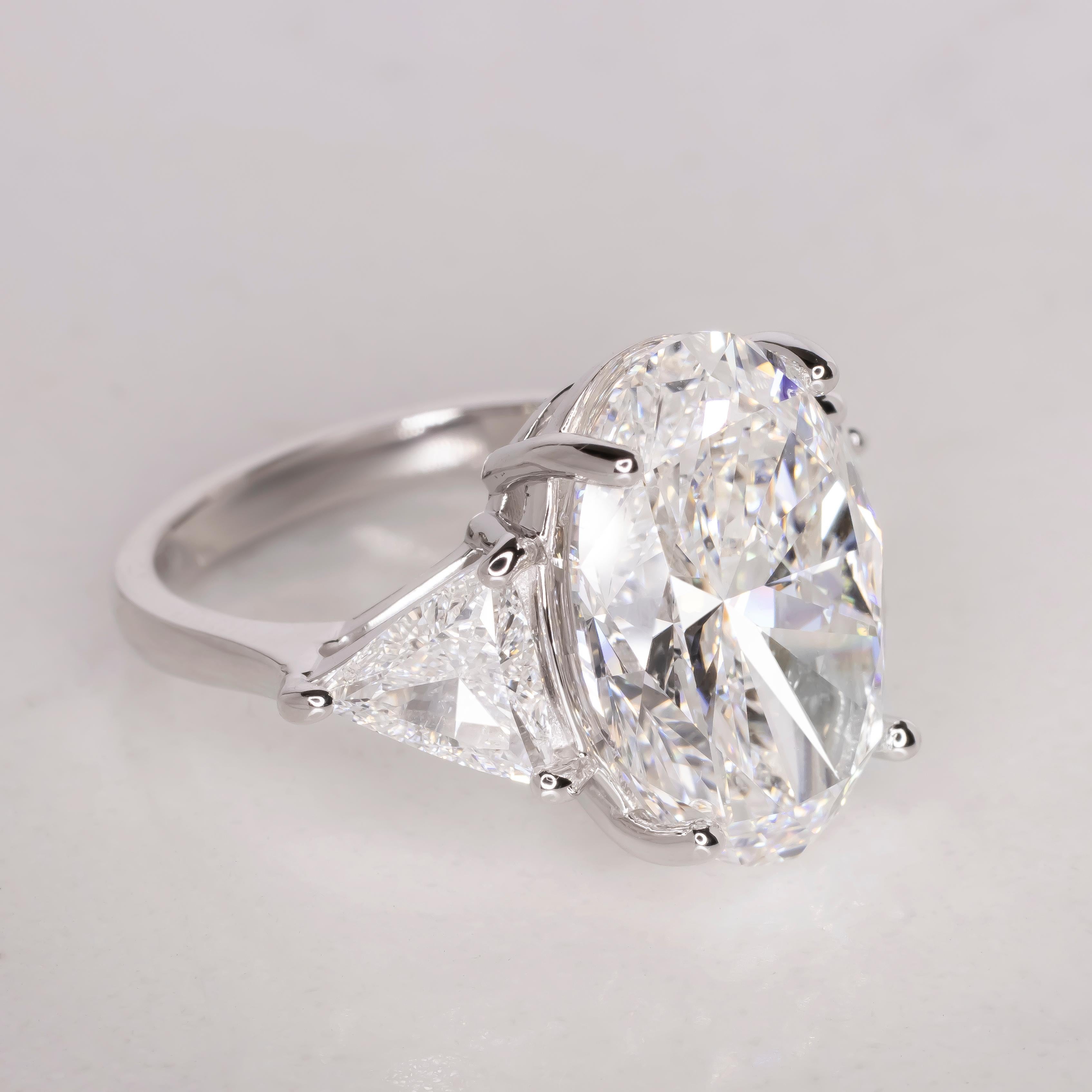 This remarkable ring features a stunning 10.01 carat oval diamond, expertly set in a platinum band. 

The GIA certified diamond is beautifully complemented by two trillion-cut diamonds, adding to its overall brilliance and elegance. The centerpiece