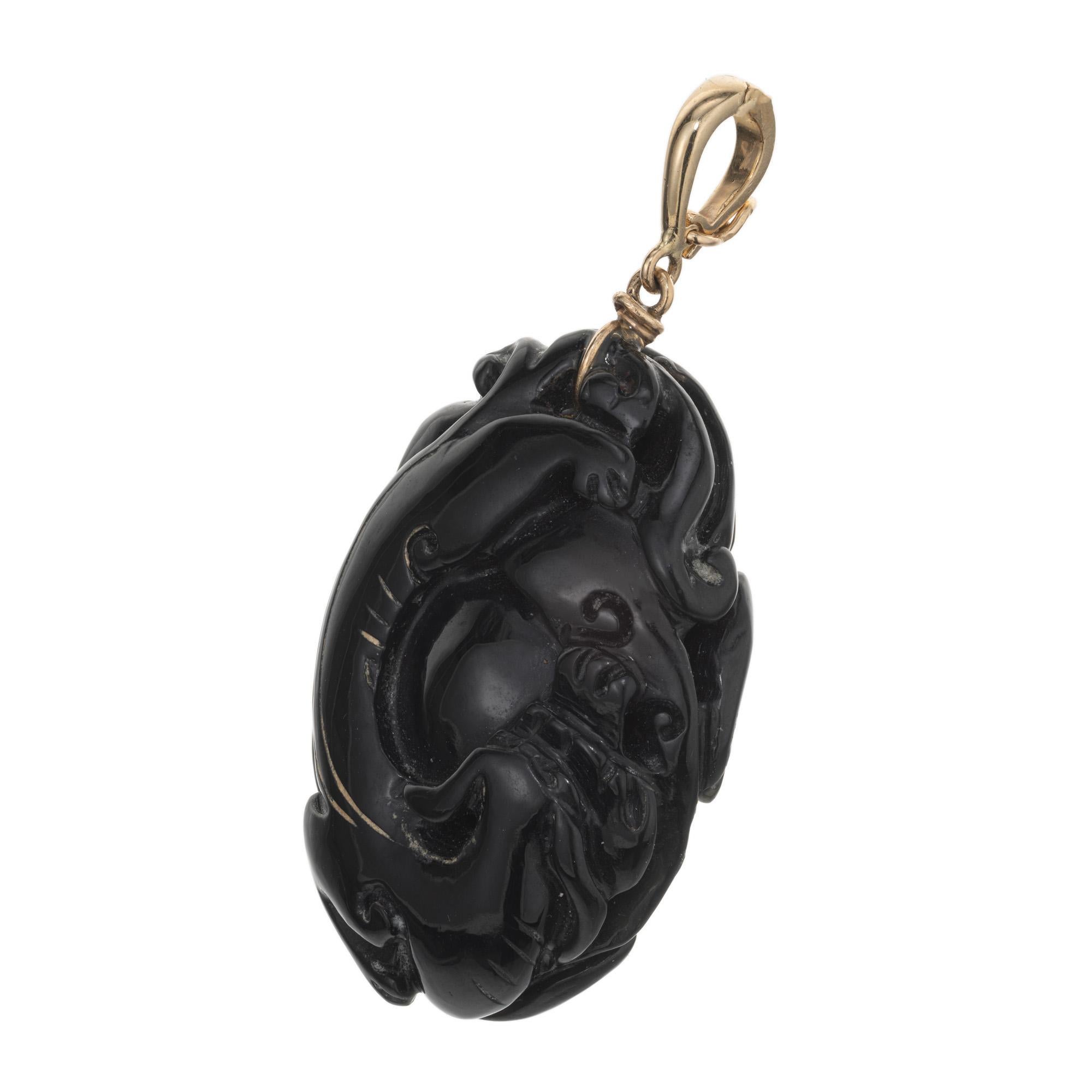 Ciondolo in nefrite naturale certificata GIA del 1930. Questo raro ciondolo di giada verde scuro da 1,00cts è scolpito con am designs di animali e fiori su ogni lato della gemma. Attaccato con un castone in oro giallo 14k per una catena. 

1