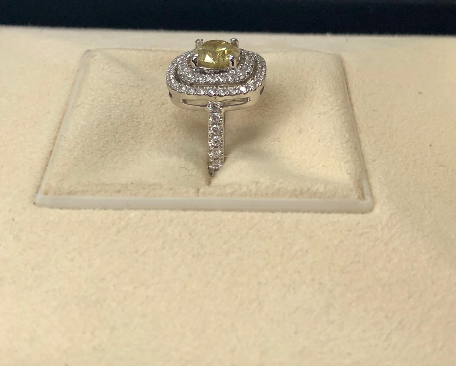 Fancy intense yellow natural round diamond weighing 1.00 carats by GIA. Set in a double row white diamonds halo setting. Its transparency and luster are excellent. 18K white gold, this pear ring is the ultimate gift for anniversaries, birthdays, and