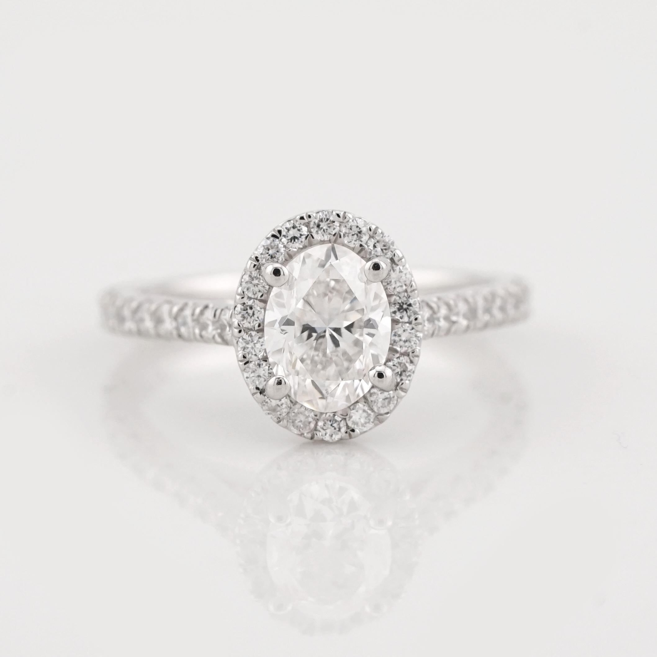 This exquisite platinum engagement ring by Cecile Blake is a stunning display of elegance and timeless craftsmanship. At its center is a GIA-certified 1.00-carat oval diamond, graded H in color and VS2 in clarity, with exceptional brilliance and
