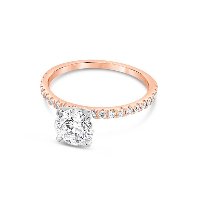 A 14 karat rose gold engagement ring featuring a 1.00ct round brilliant cut natural diamond, F SI1, with 0.27ct total weight in round brilliant cut diamonds along the band. This ring is currently a size 7 but can be resized upon request. 
GIA