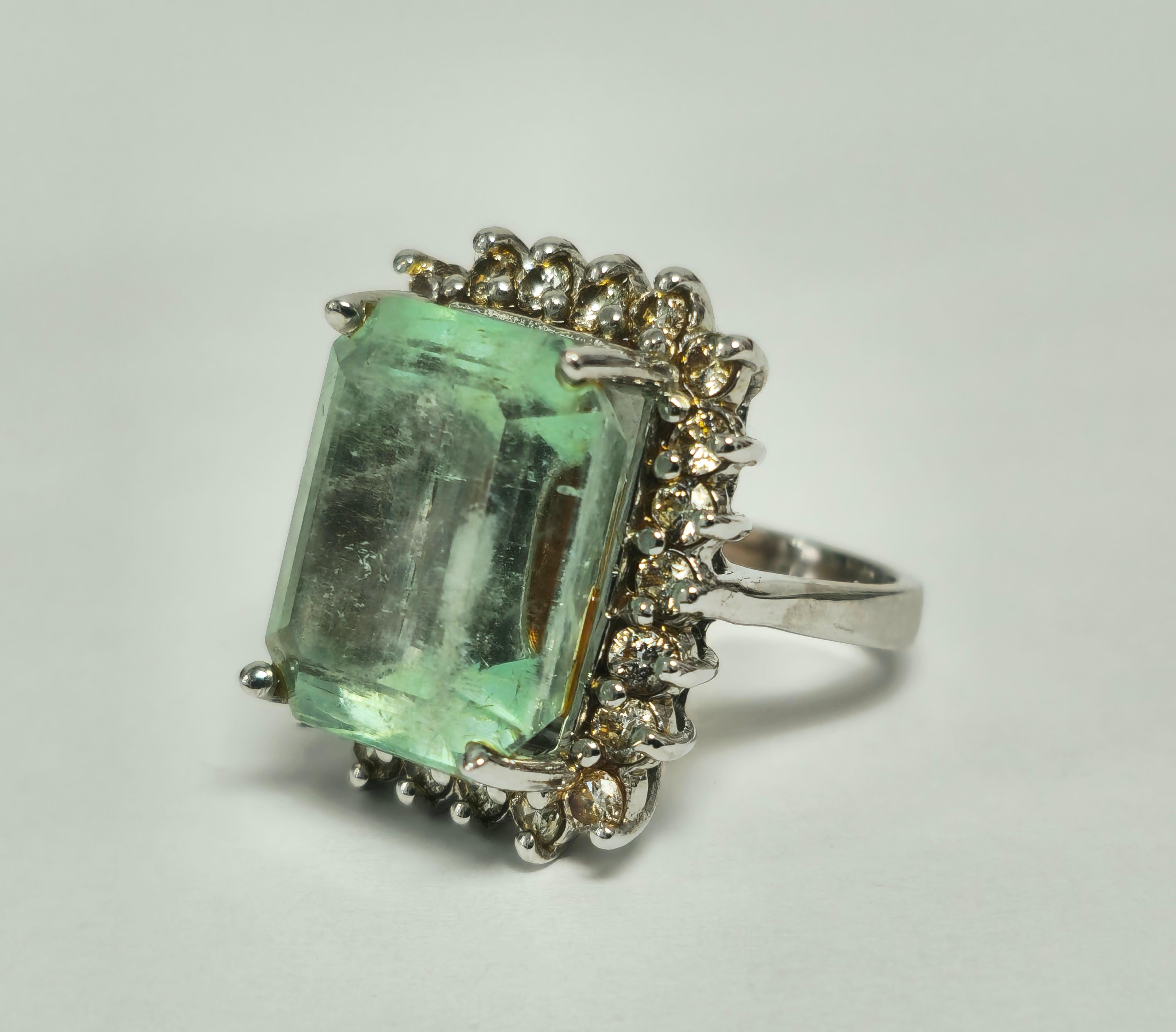 Erhöhen Sie Ihren Stil mit unserem Contemporary Emerald Ring für Damen, der mit einem atemberaubenden kolumbianischen Smaragd in glänzendem Weißgold besetzt ist. Dieses seltene und einzigartige Schmuckstück ist mit schillernden runden Diamanten im