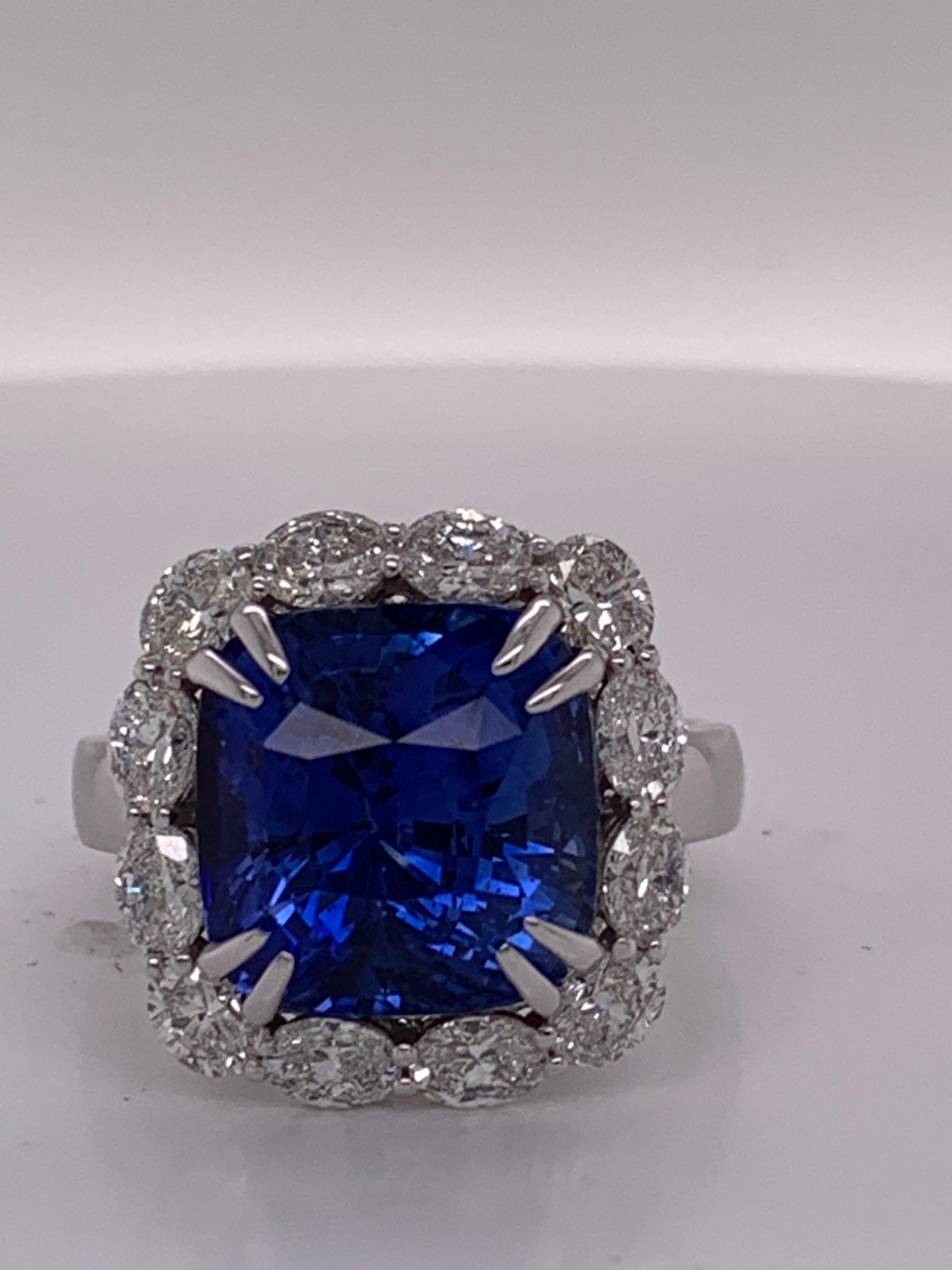 This magnificent halo ring boasts a delightful combination of blue sapphire & white diamonds. A cushion cut sapphire is set in prongs and framed by a glistening oval diamond halo. This heirloom piece is hand finished by our highly skilled