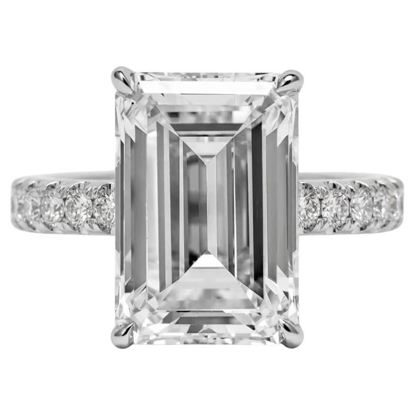 uno straordinario diamante con taglio smeraldo da 10,03 carati, messo in mostra in un anello di platino con una raffinata fascia di diamanti incastonati a pavé. Certificata da GIA con colore J e purezza VS2, questa magnifica pietra offre una