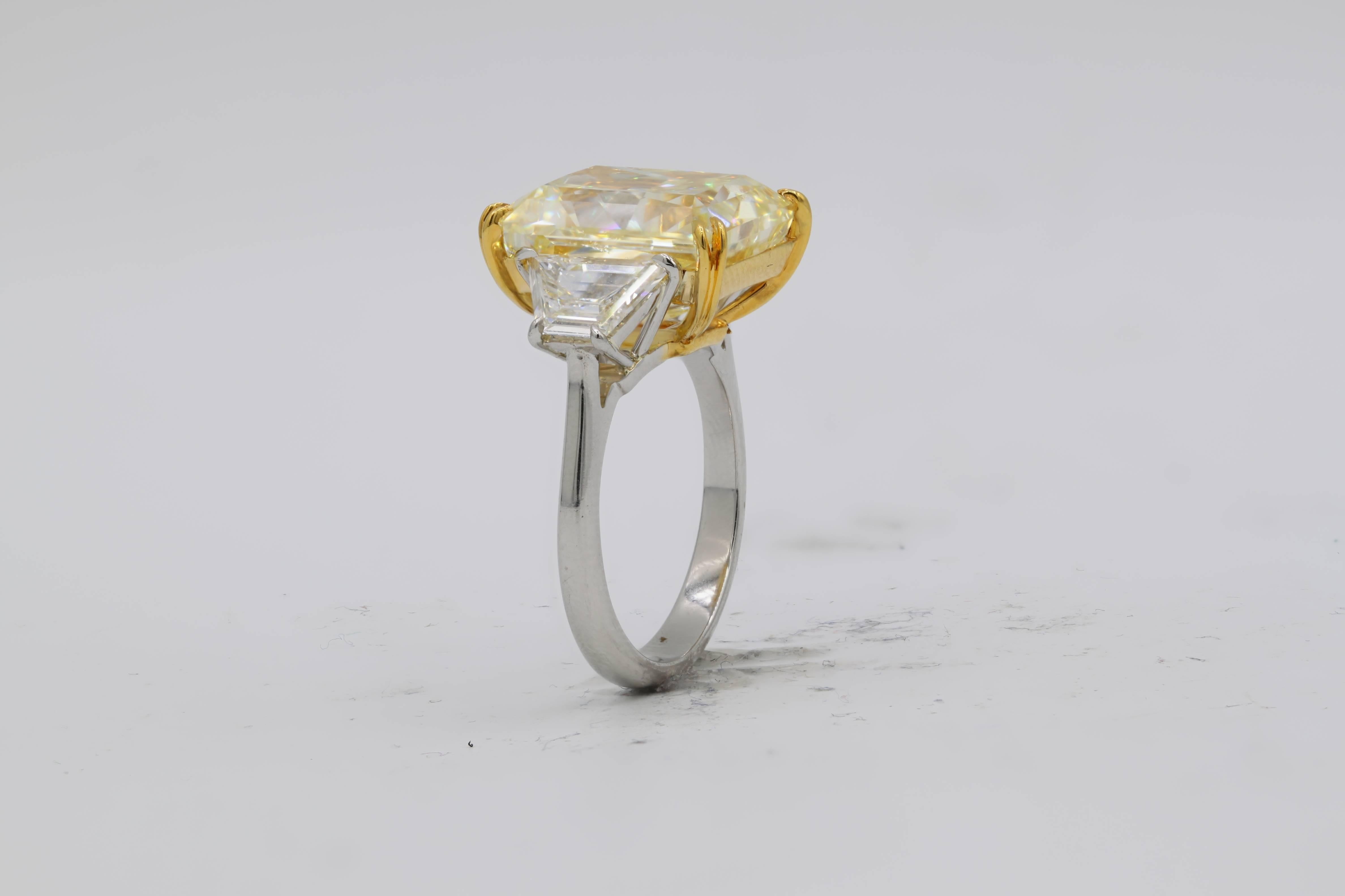 Atemberaubender kanariengelber Diamant mit drei Steinen  Ring, sehr seltener länglicher Radiant, schöne leuchtende Farbe.
Der Mittelstein ist 10,03 Karat Fancy Yellow SI1 in Clarity Radiant. Mit 1,21 Karat Trapezoiden auf jeder Seite besetzt. In