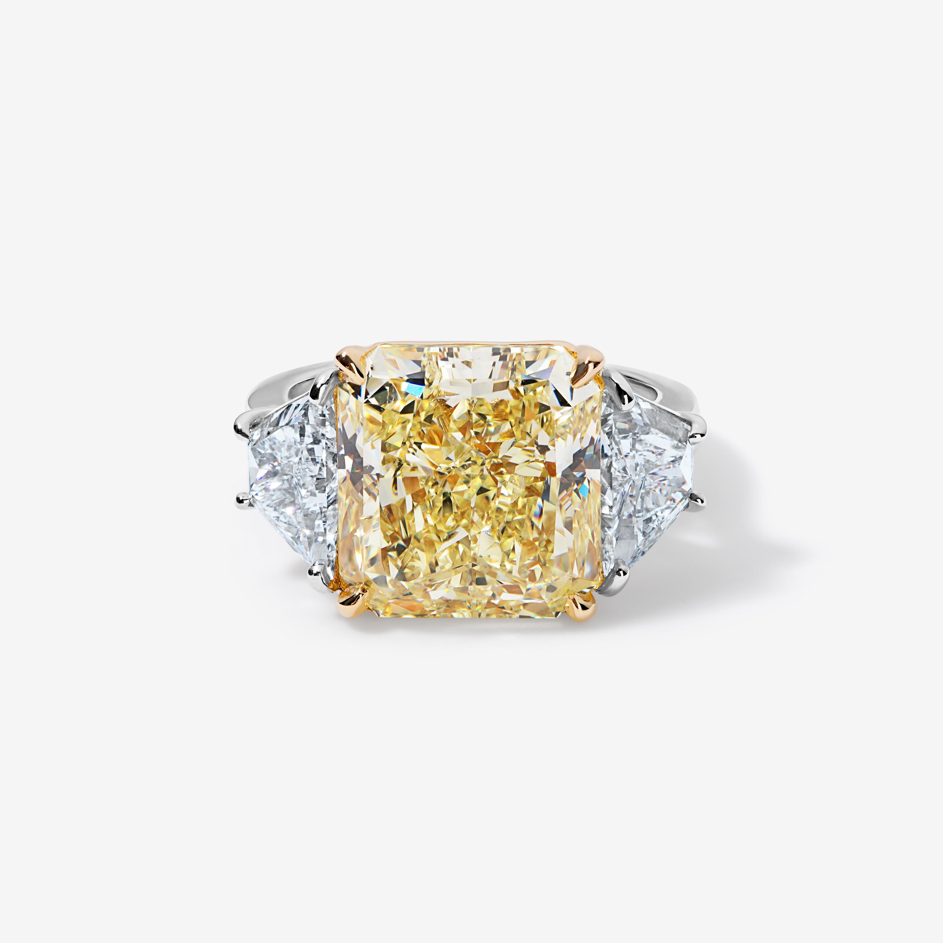 For the woman who wants to wear the sun on her finger.

This 10 carat fancy yellow radiant cut diamond is nestled between two trapezoid white diamonds. It shows strong evenly saturated color, is eye clean, and shows more size than other stones of