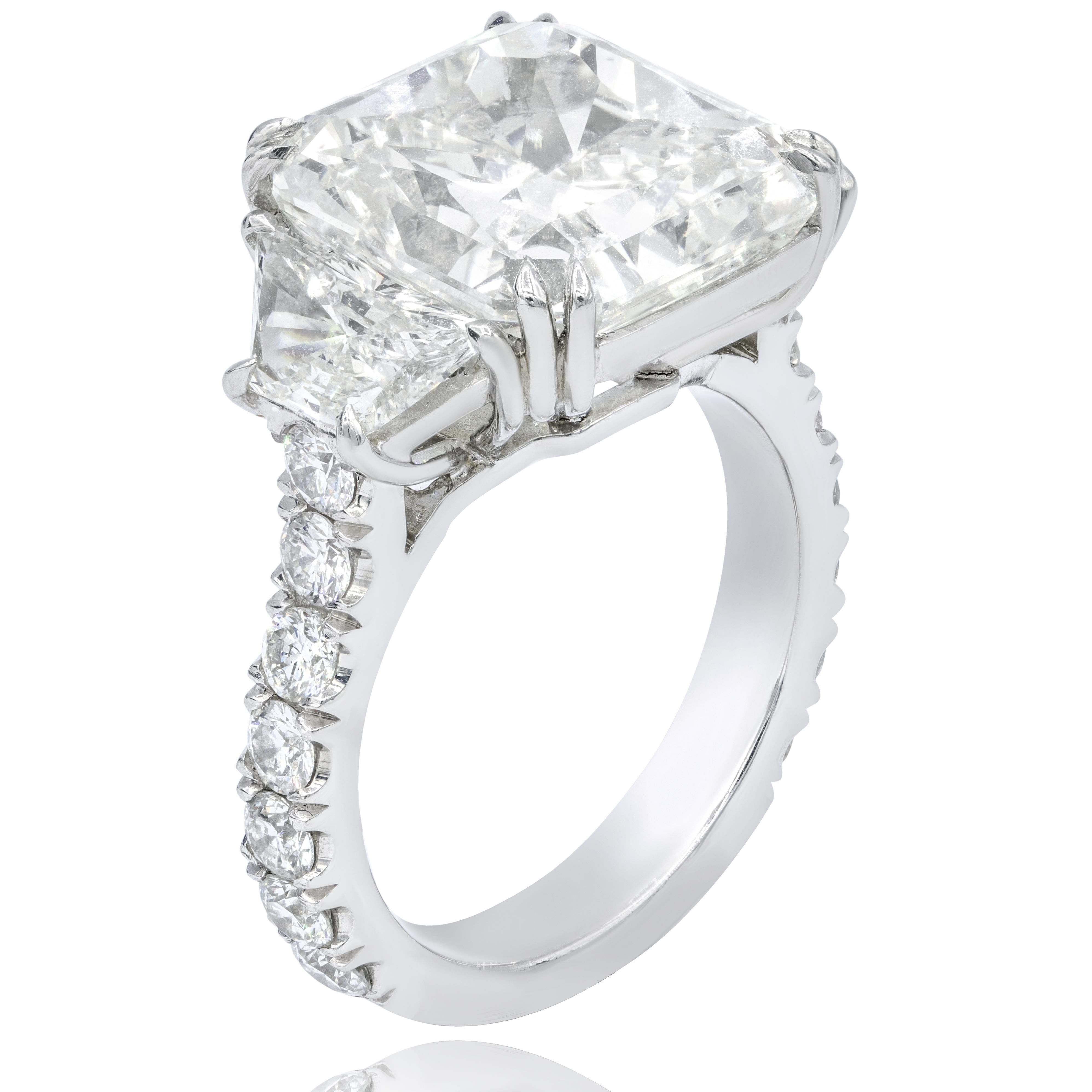 Platinum handmade diamond ring, features 10.08 Carats Radiant Cut diamond, J in Color SI1 in Clarity, certified by GIA, surrounded by 2.00 carats of trapezoids and round brilliant cut diamonds.
