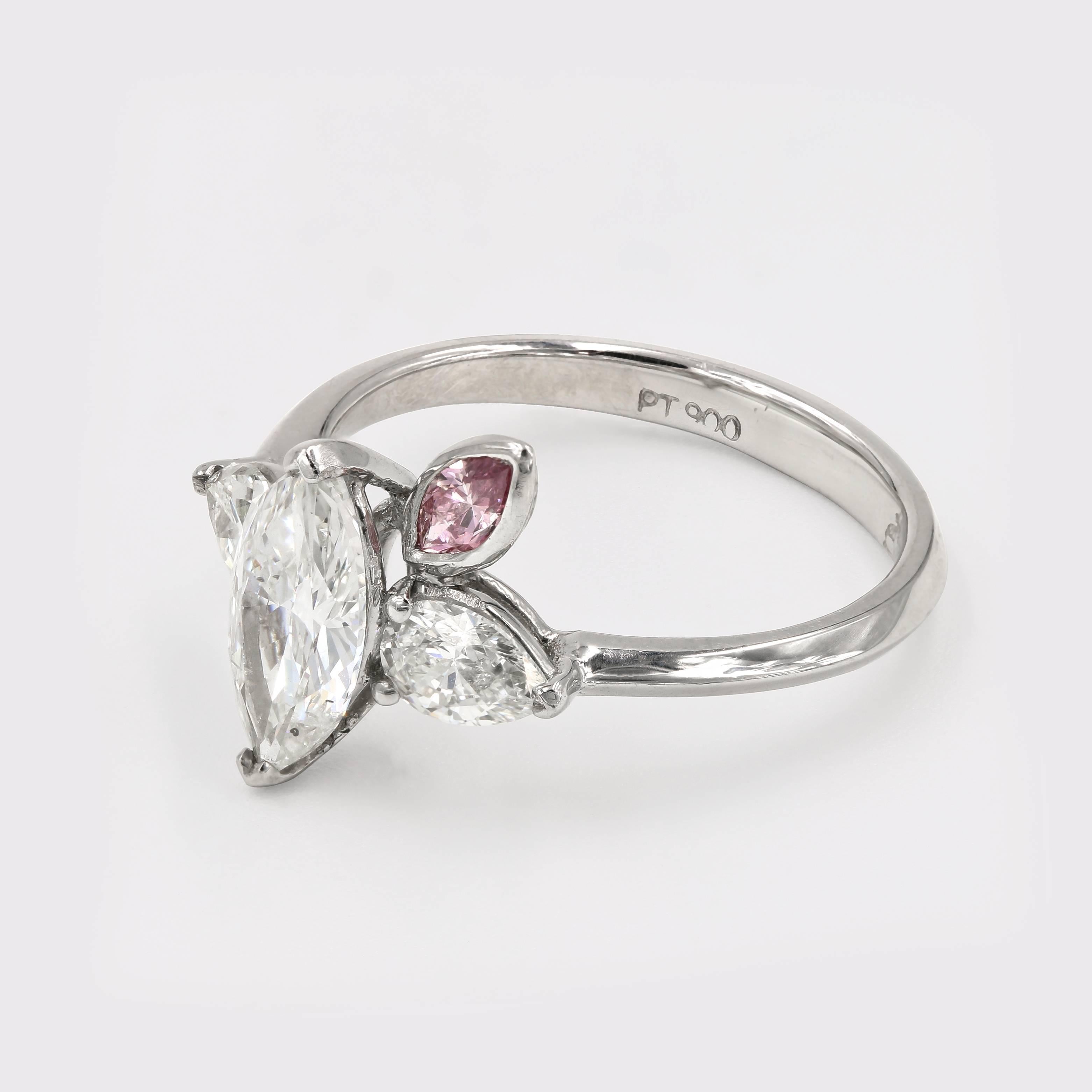 This special ring, set in platinum, has a center marquise diamond= 1.01cts. I color and SI2 clarity. There are 2 pear shape diamonds on the sides of the center stone=.63ct. t.w. J color and VS2 clarity. Accenting the center is the intense purplish -