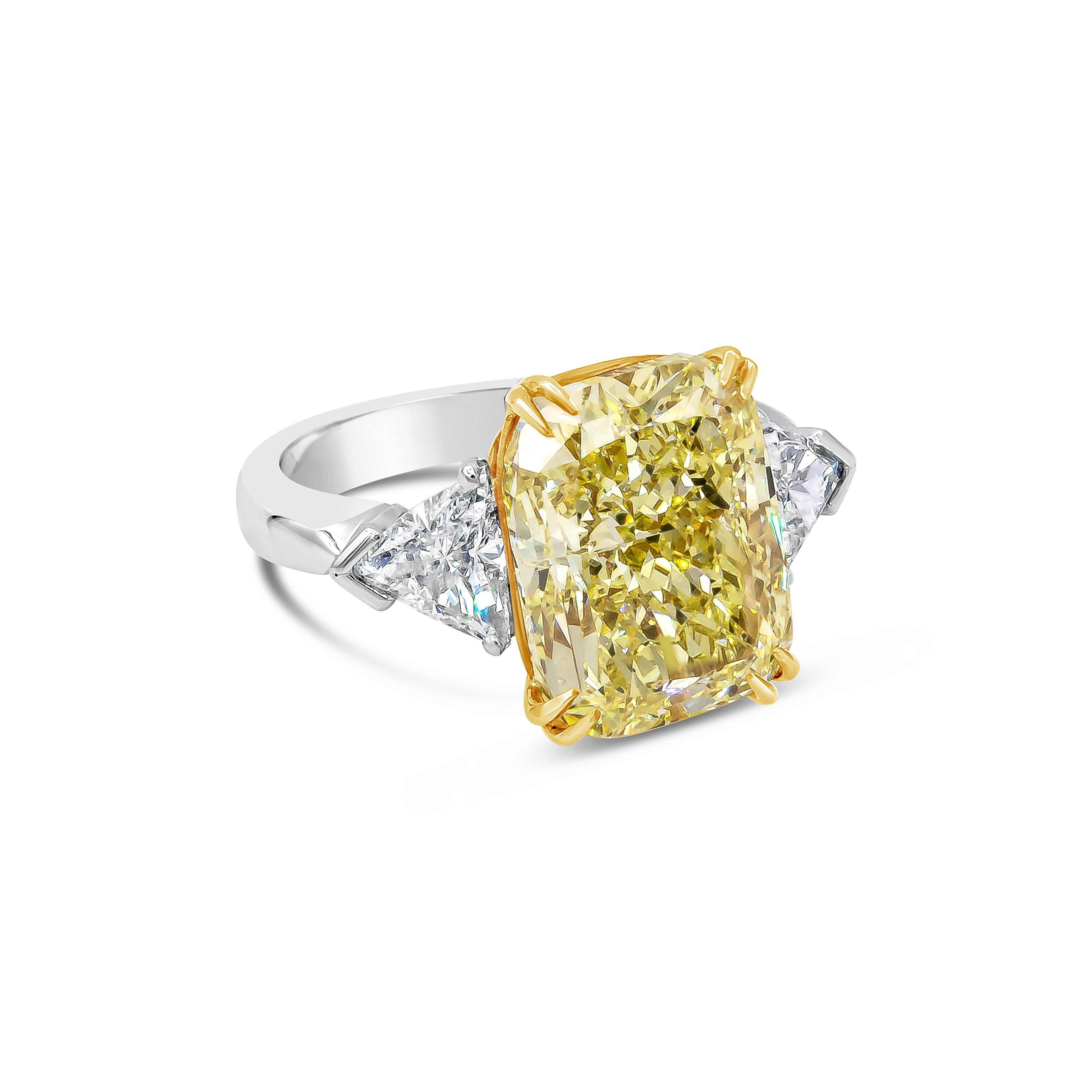 Showcases a color-rich 10.11 carats cushion cut diamond that GIA certified as Fancy Yellow color and SI1 in clarity, set in eight prong 18K yellow gold. Accented with trillion cut diamond on each side weighing 1.25 carats total. Finely made with