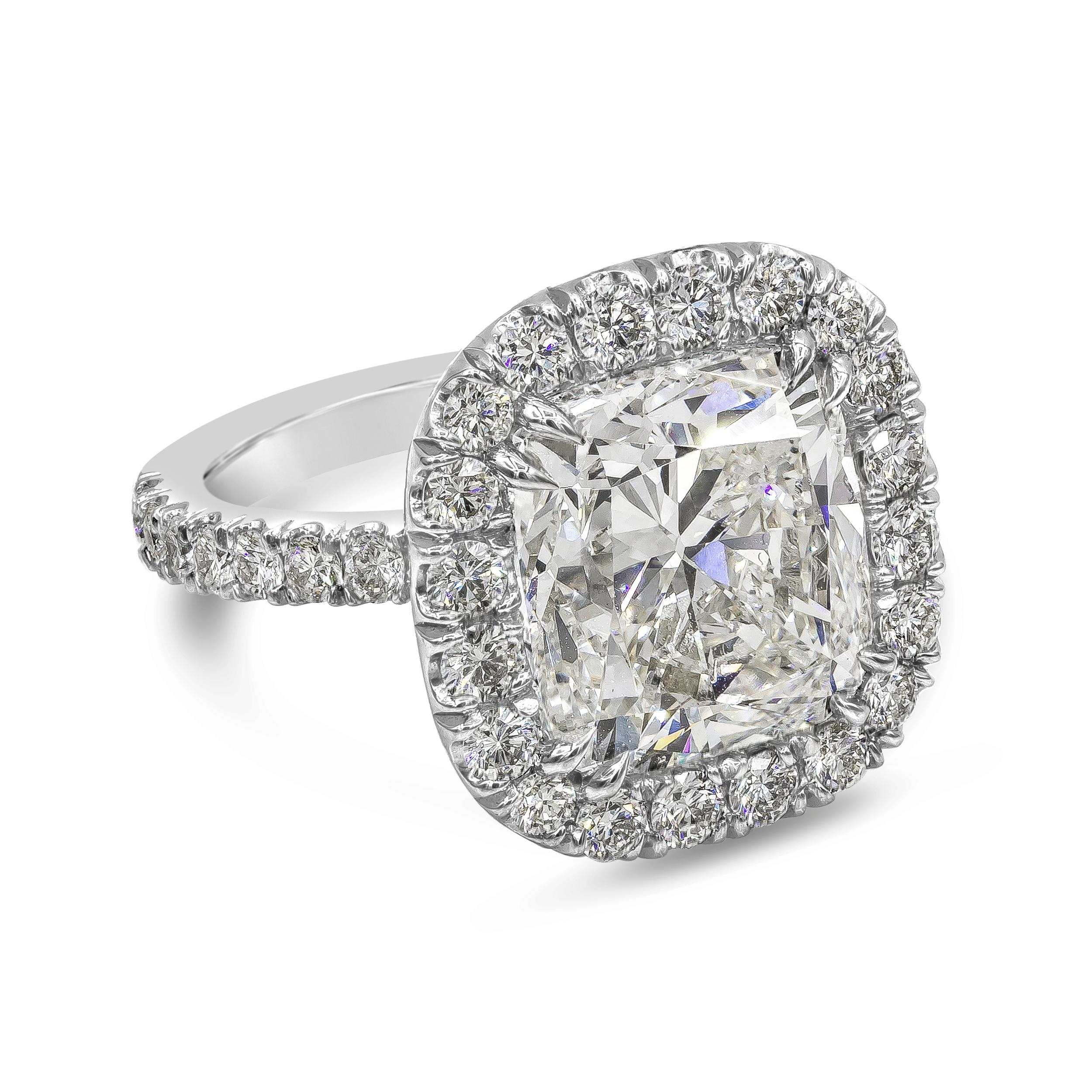 A chic jewelry piece showcasing a GIA Certified 10.12 carat cushion cut diamond, J Color and SI1 in Clarity. Surrounding the center diamond is a row of round brilliant diamonds, set in an accented basket and band weighing 1.90 carats total. Made