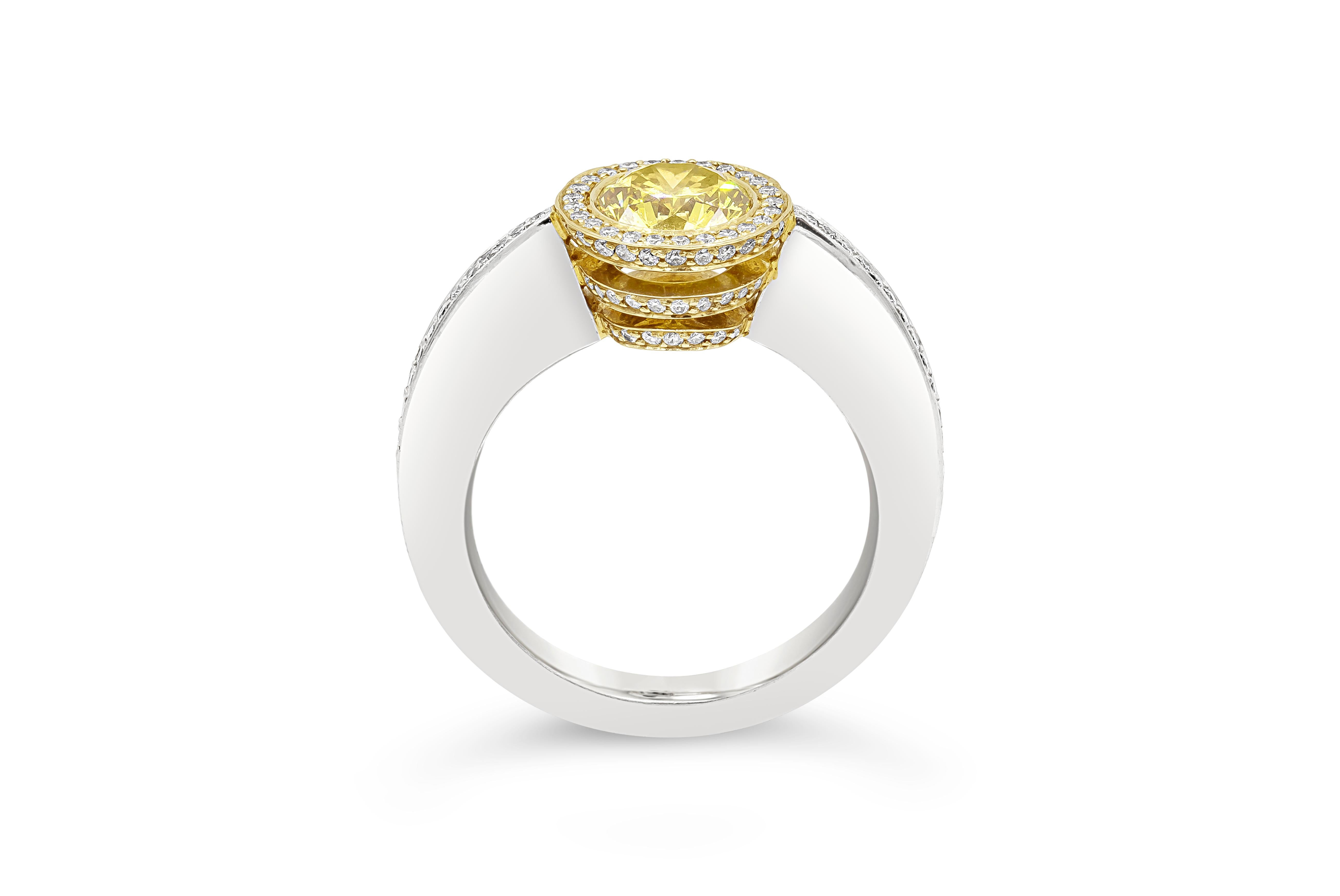 A unique engagement ring, showcasing a bezel-set 1.02 carat yellow diamond certified by GIA as Fancy Deep Brownish Yellow color and VS2 clarity, surrounded by white diamonds in a halo design and mounted on 18K yellow gold. The shank is encrusted