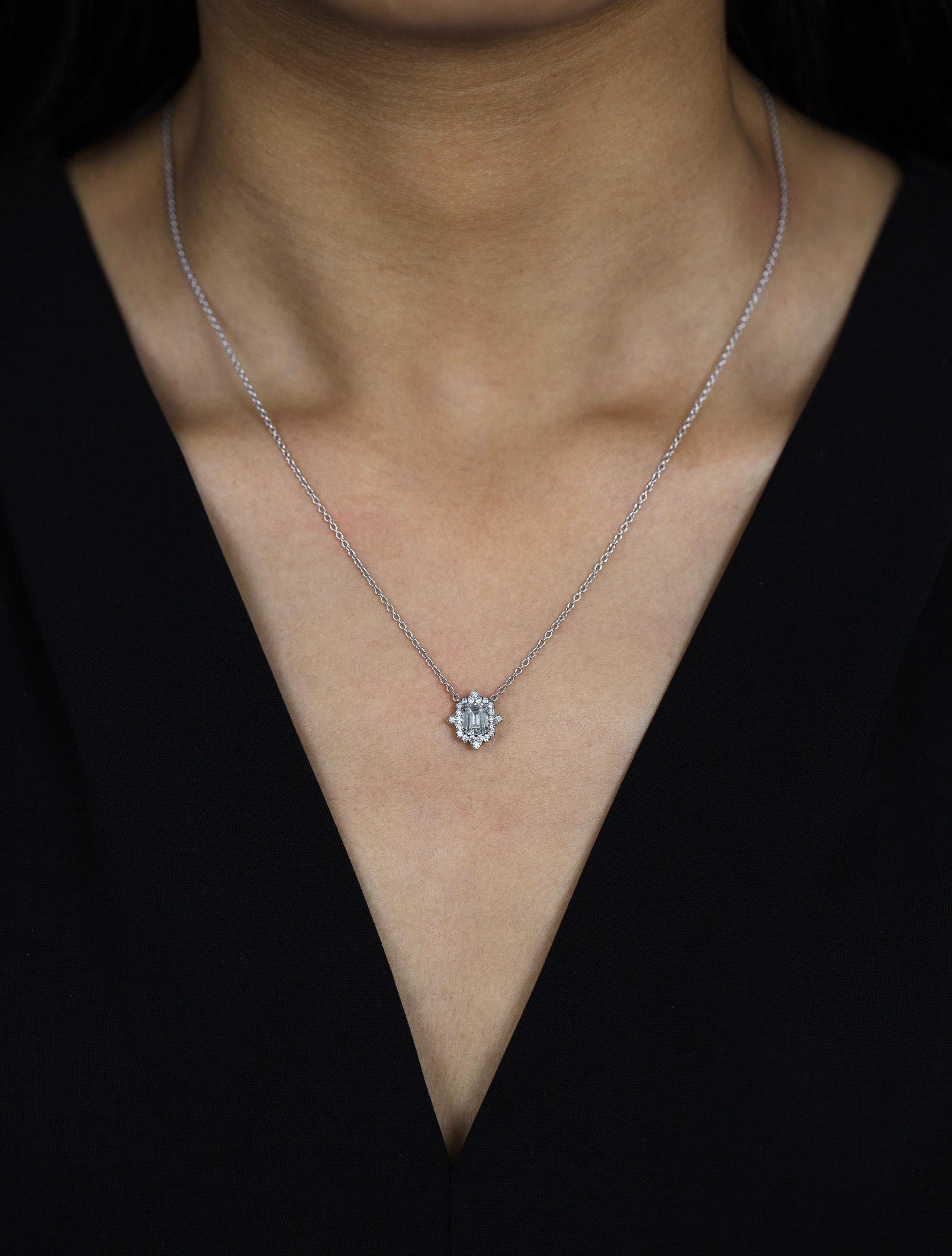 A fashionable pendant necklace showcasing a 0.80 carats emerald cut diamond certified by GIA as I color, VVS2 in clarity. The center diamond is surrounded by a row of round brilliant diamonds weighing 0.22 carats total. Made in platinum. Suspended