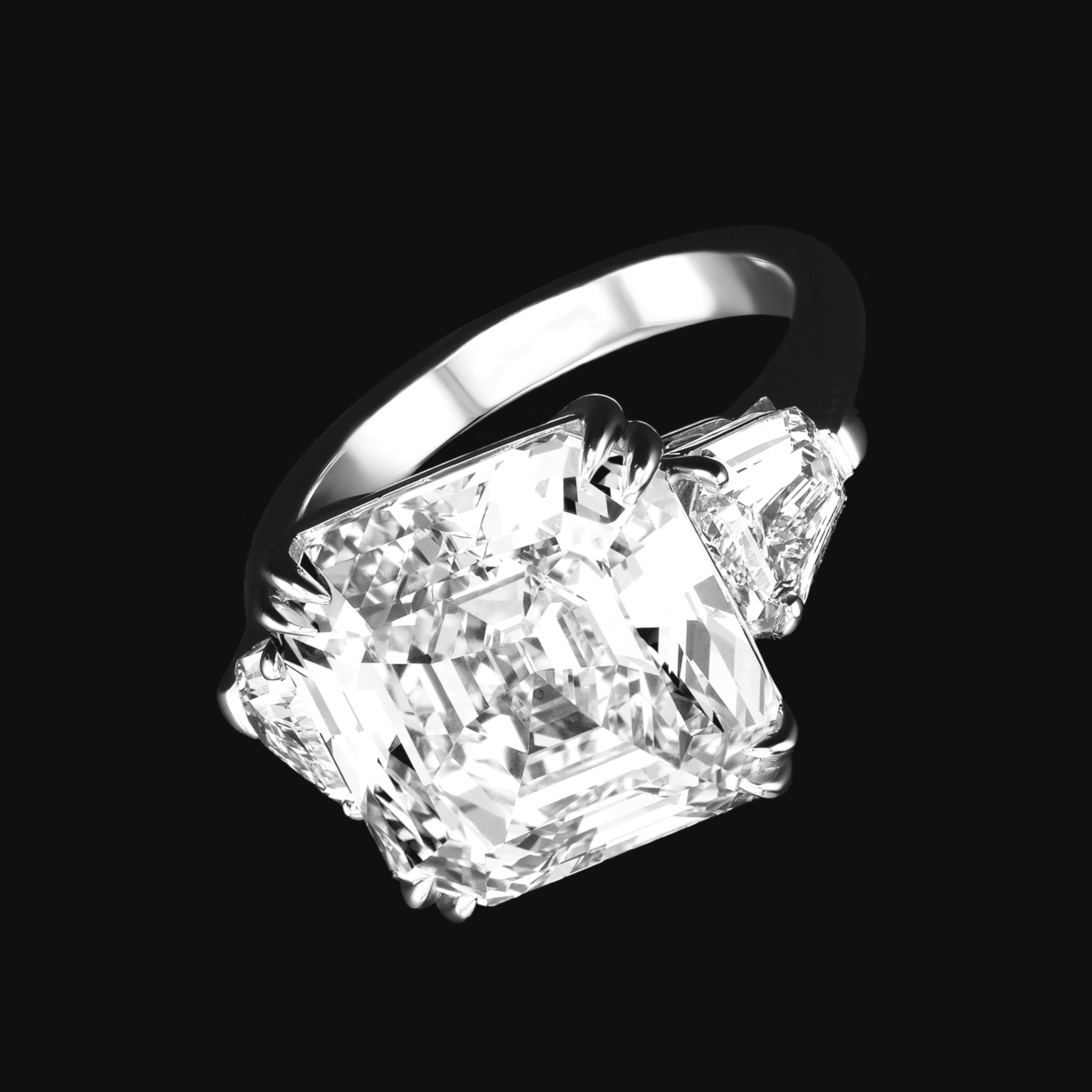 An exquisite 10.22 square emerald diamond ring flanked by a matched pair of 1 cttw Shield cut E – F VS, all diamonds

