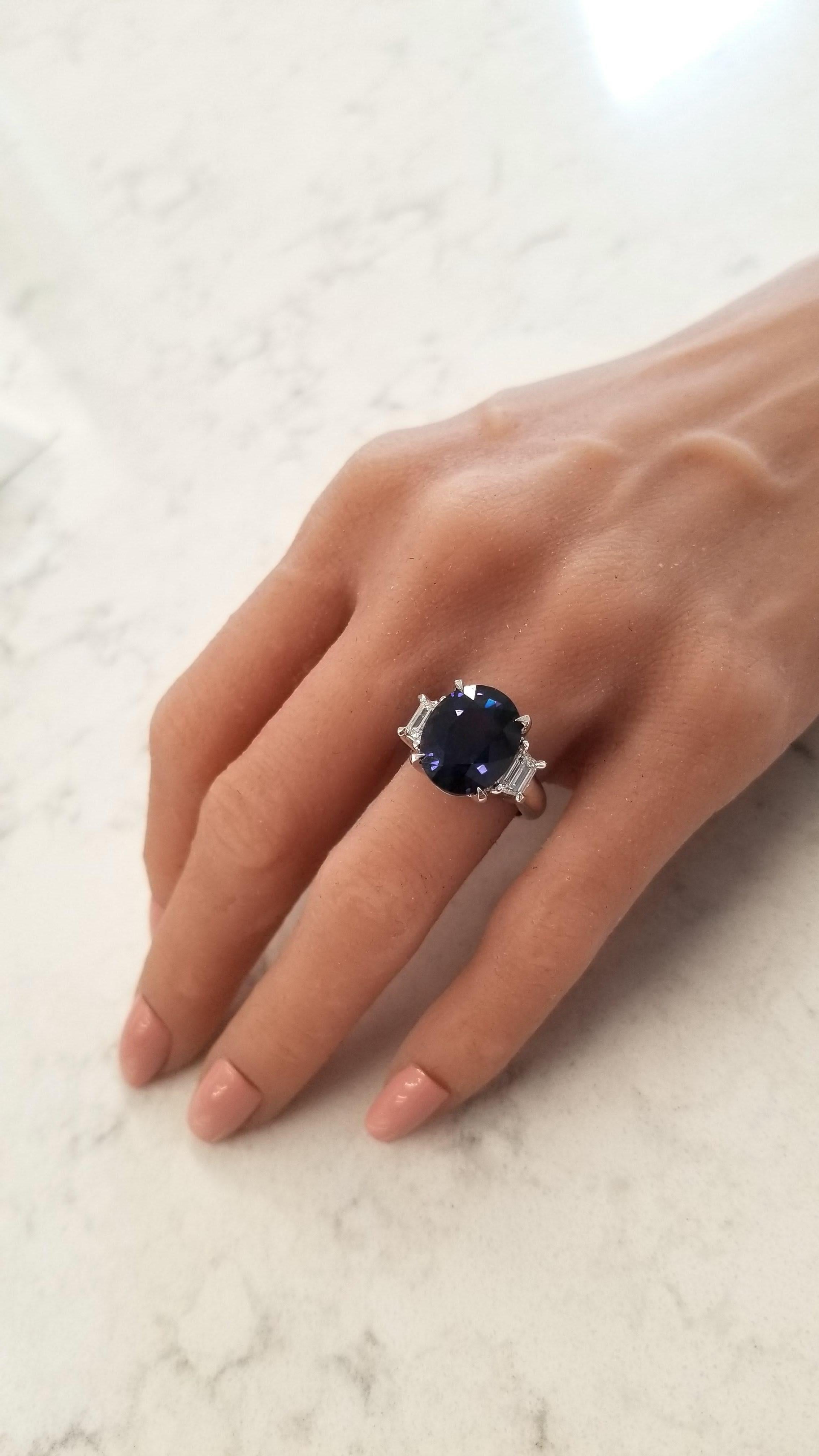 This ring showcases an uncommon natural color-change sapphire that weighs 10.26 carats and exudes a color-change range from violetish blue to purple. The gem source is Sri Lanka; its luster, clarity, and transparency are superb. Two trapezoid