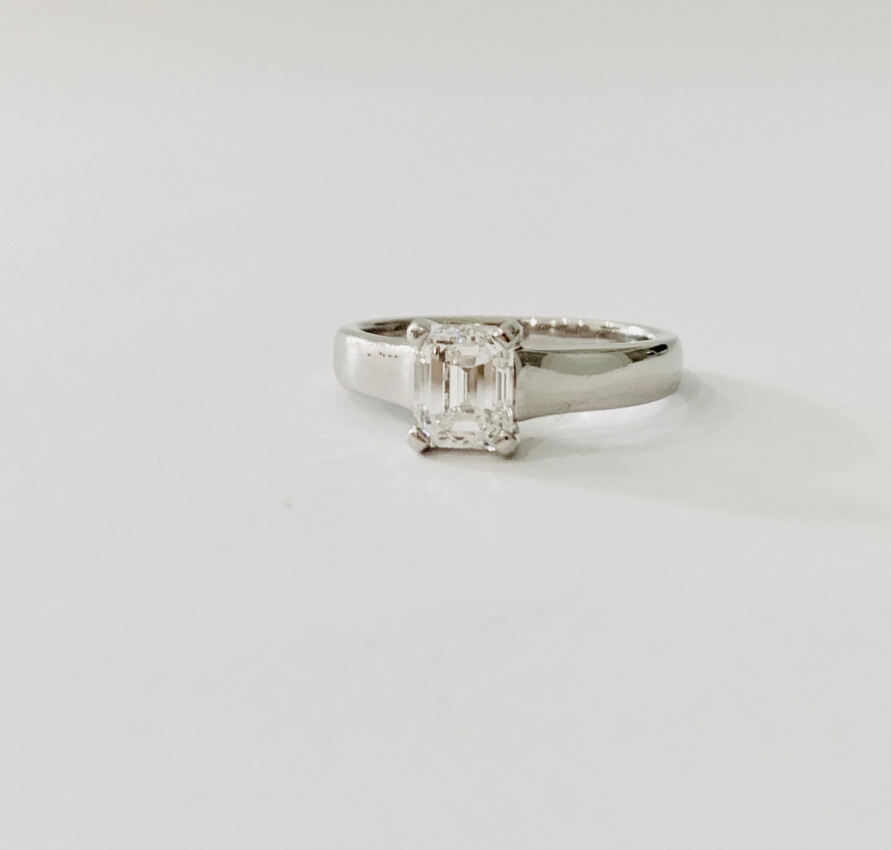 A stunning Emerald Cut Diamond set in a  modern Platinum band and is GIA Certified as Colour H and VS1 Clarity.  The diamond is quite breathtaking when it shows flashes of colours of the rainbow and for an emerald cut, with less facets than a