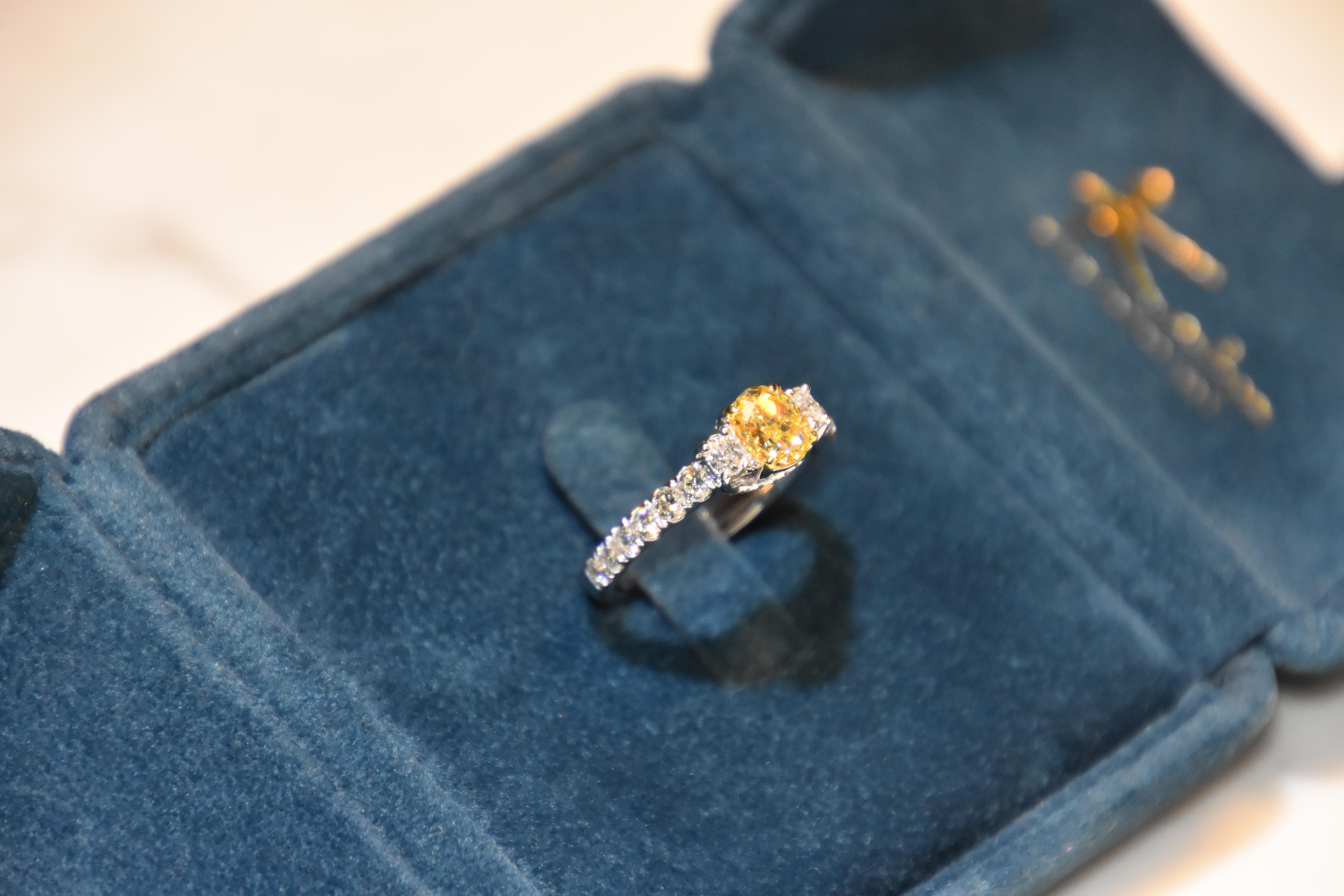 Featuring a 1.03 carat Fancy Yellow diamond with 2 pieces oval diamond on the side, simple elegant as a 3 stone ring. Shank finished with white diamond in white gold. 

Center stone certified by world wide known GIA institution. (1168362478) 

Ring