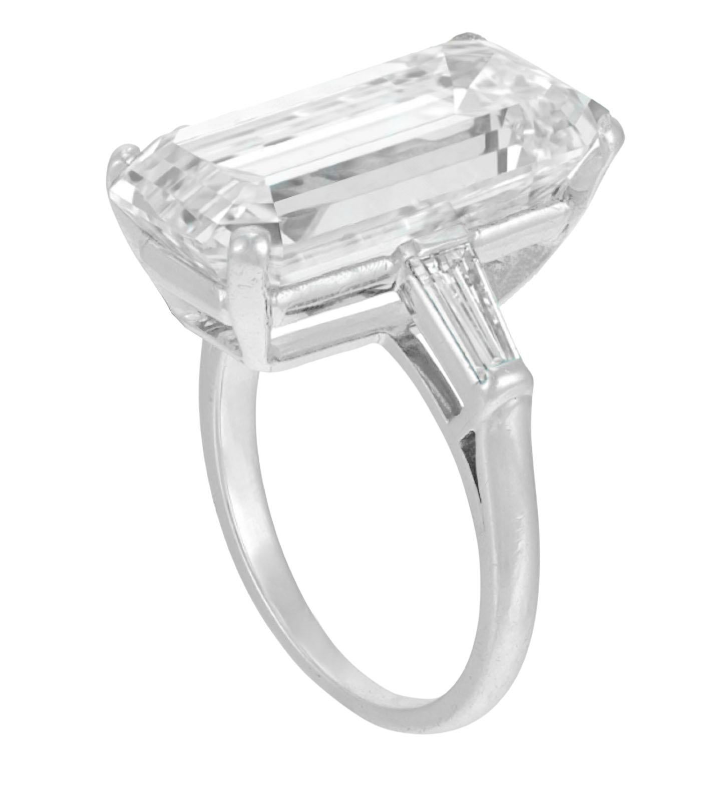 GIA Certified 8 Carat Emerald Cut Diamond Solitaire Engagement Ring. 
The main diamond is a Round Brilliant Cut diamond weighing 8 ct, E in color, VVS2 in clarity. The center stone has an Excellent Polish, Excellent Symmetry, and faint fluorescence.