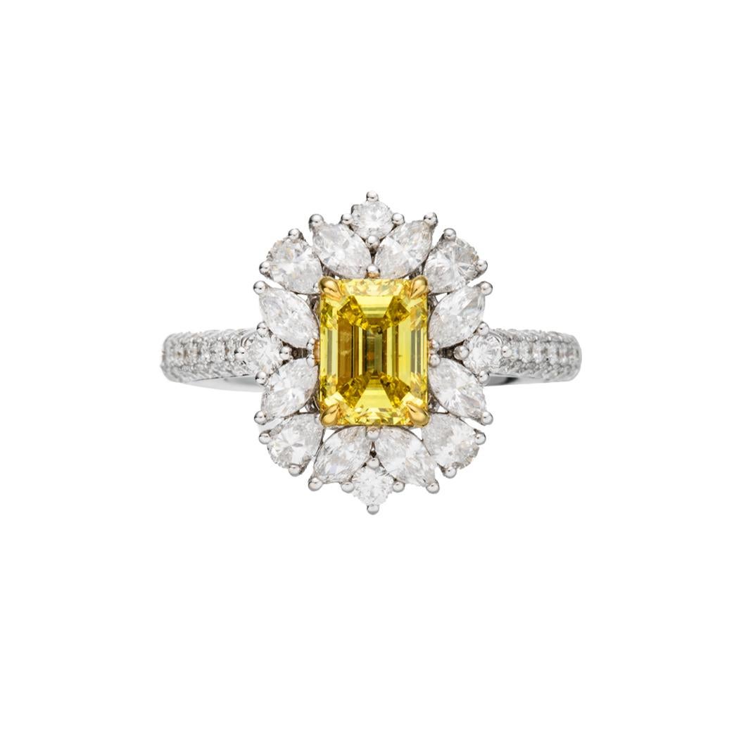 This exceptional ring proudly features a mesmerizing GIA-certified 1.03-carat Fancy Vivid Yellow emerald-cut diamond as its centerpiece, encapsulated in an 18-karat gold setting. The diamond emits a vibrant and intense yellow hue, a rarity in the