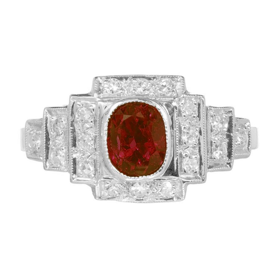 Ruby and diamond Art Deco halo engagement ring. From the early 1900's exquisite piece features a vibrant 1.04ct oval ruby mounted in a three tiered platinum mounting. Accented by 19 single cut diamonds. The fusion of rich red hues from the ruby and
