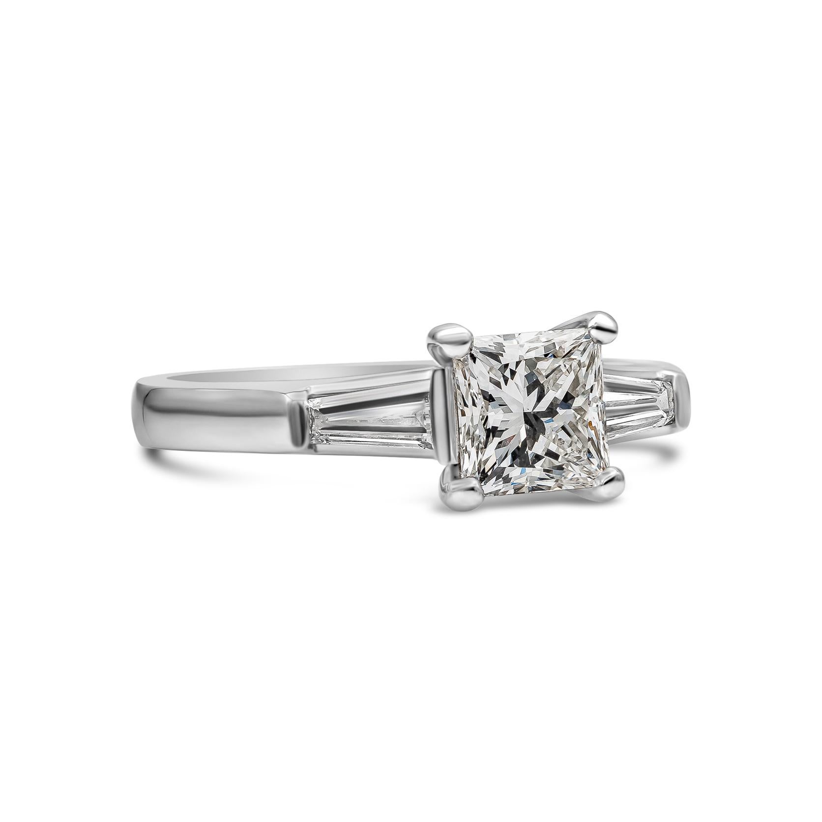 This simply and classy three-stone engagement ring Features a 1.04 carats princess cut diamond certified by GIA as I color, VS2 in clarity, flanked by two tapered baguette diamonds on either side weighing 0.33 carats total. Set in a polished