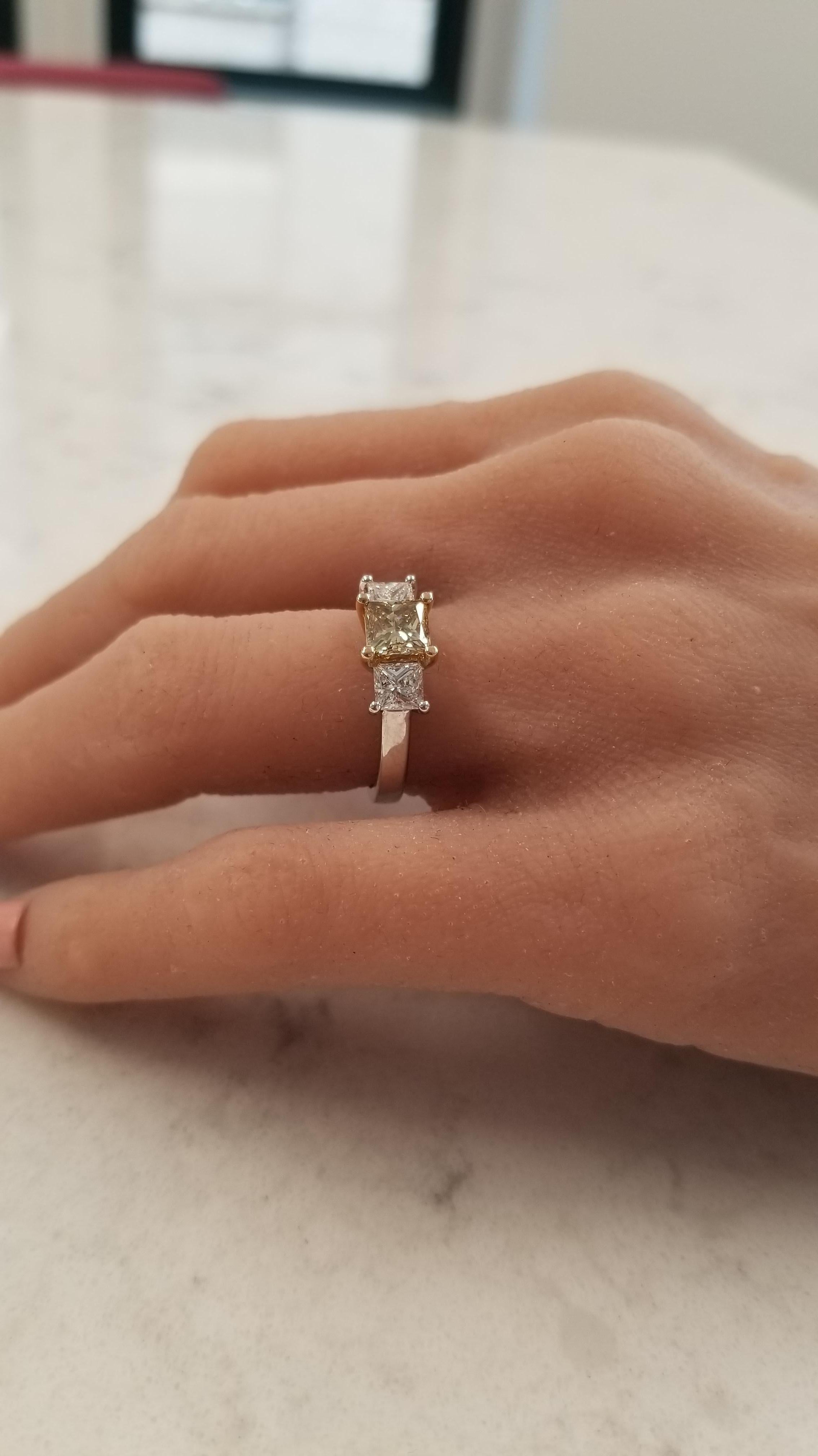 This 3-stone ring is the ultimate gift to give for anniversaries or engagements. A 1.04 carat princess cut, prong set, GIA certified, natural fancy brownish yellow diamond takes center stage with measurements of 5.60-5.55MM. Two white princess cut