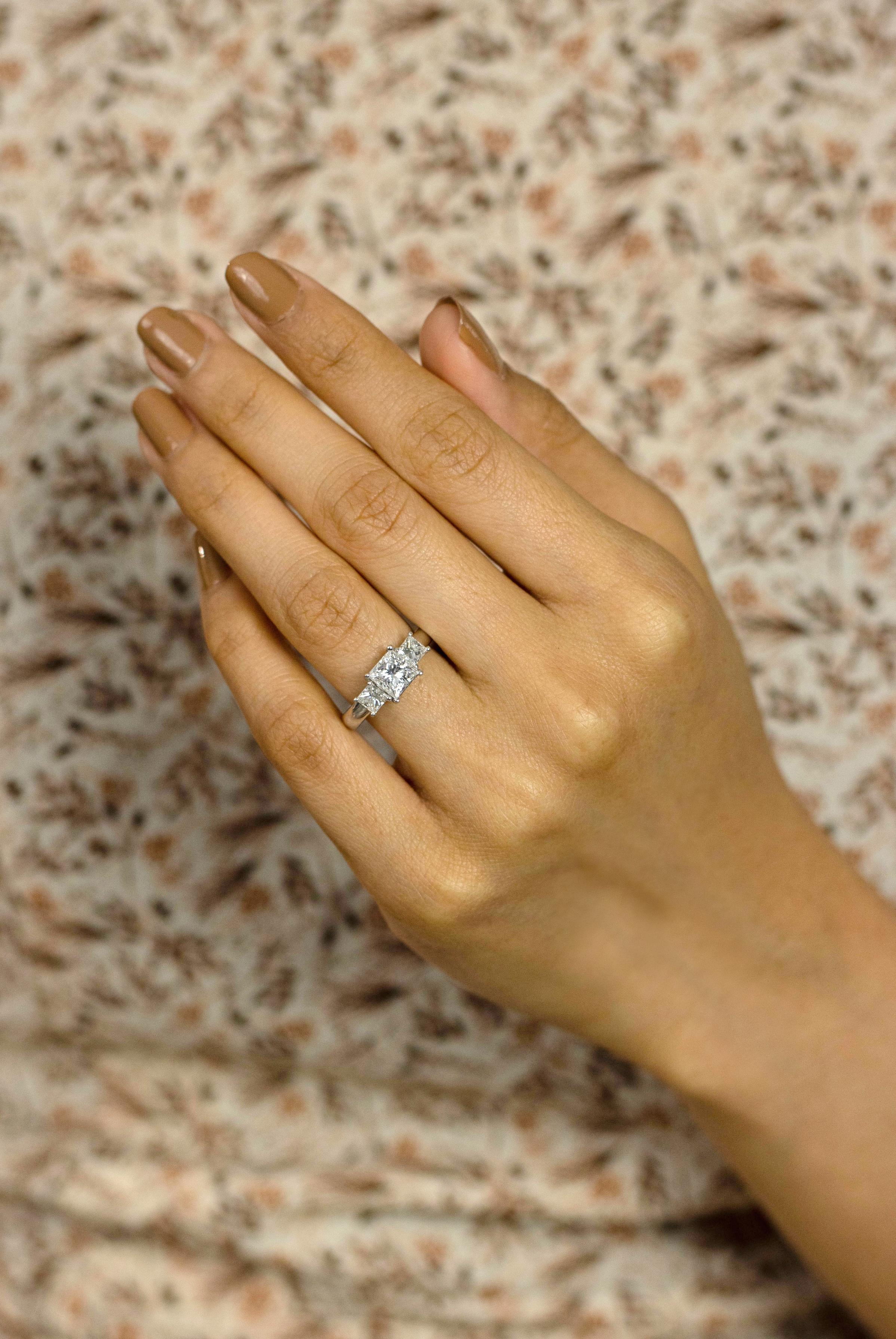 Dieser luxuriöse Verlobungsring besteht aus einem 1,04 Karat schweren Diamanten im Prinzessschliff in der Mitte, flankiert von Diamanten im Prinzessschliff auf jeder Seite. Die Akzentdiamanten wiegen insgesamt 1.00 Karat. Jeder Diamant ist in einem