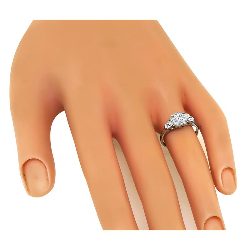 This is a fabulous platinum engagement ring. The ring is centered with a sparkling GIA certified cushion cut diamond that weighs 1.04ct. The color of the diamond is I with SI1 clarity. The center diamond is accentuated by dazzling bullet cut