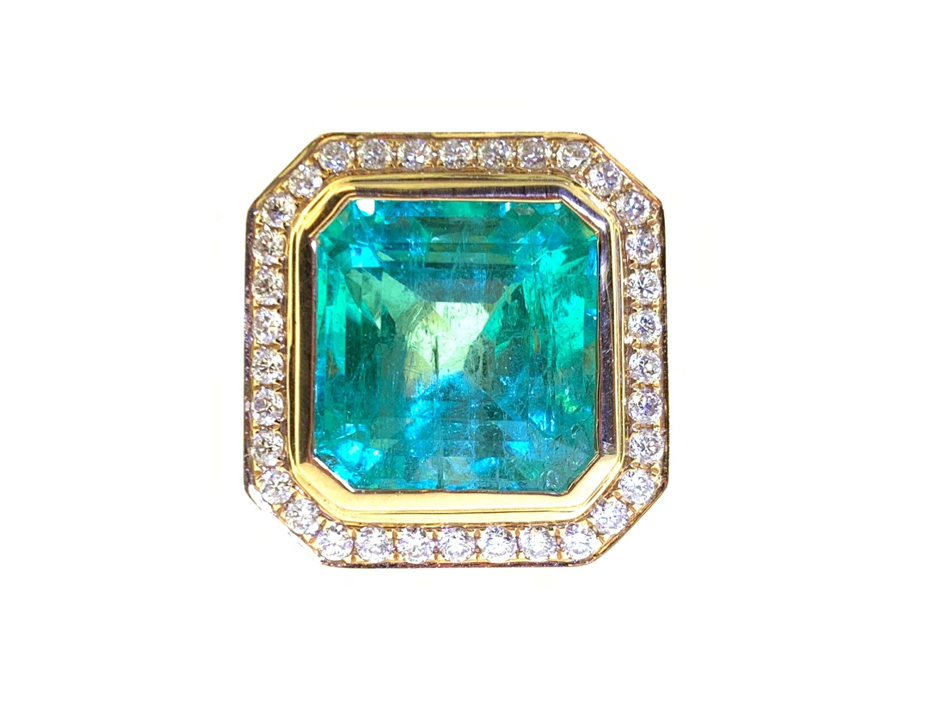 This stunning cocktail ring showcases a GIA Certified 10.51 Carat Emerald Cut Colombian Emerald, with a beautiful diamond halo. This ring is set in 18k yellow gold with the shank adorned with 3 flush sets of white baguette diamonds on each side.