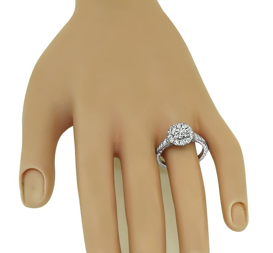 This is a charming 14k white gold engagement ring. The ring is centered with a sparkling GIA certified round cut diamond that weighs 1.05ct. The color of the diamond is G with SI1 clarity. The center diamond is accentuated by dazzling round cut