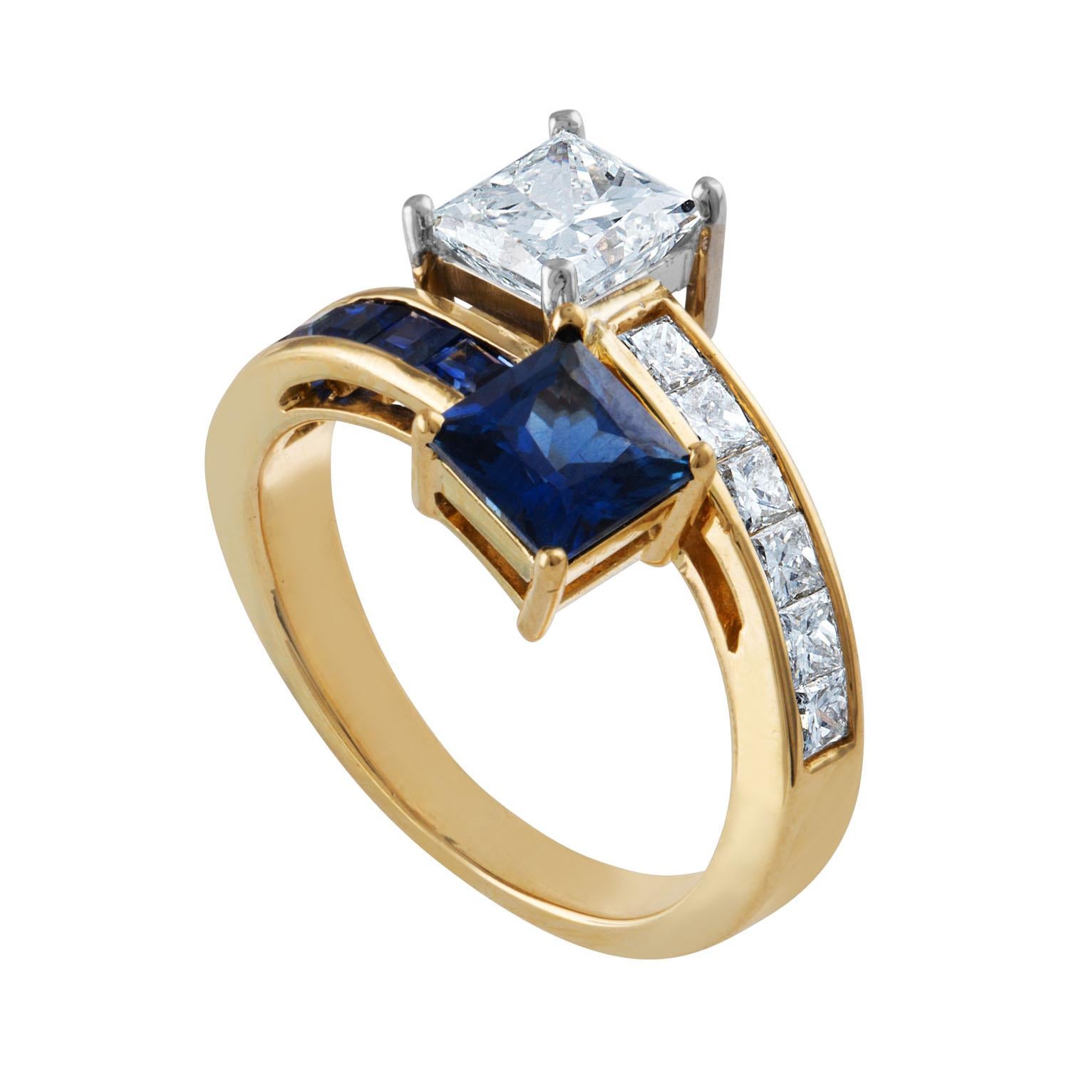Stunningly Classic Bypass Ring
The ring is 14K Yellow And White Gold
The Princess Cut Diamond is GIA Certified 1.06 Carats G VS2
The Princess Cut Blue Sapphire 1.25 Carats
There are 0.50 Carats G VS In Small Princess Cut Diamonds
There are 0.90