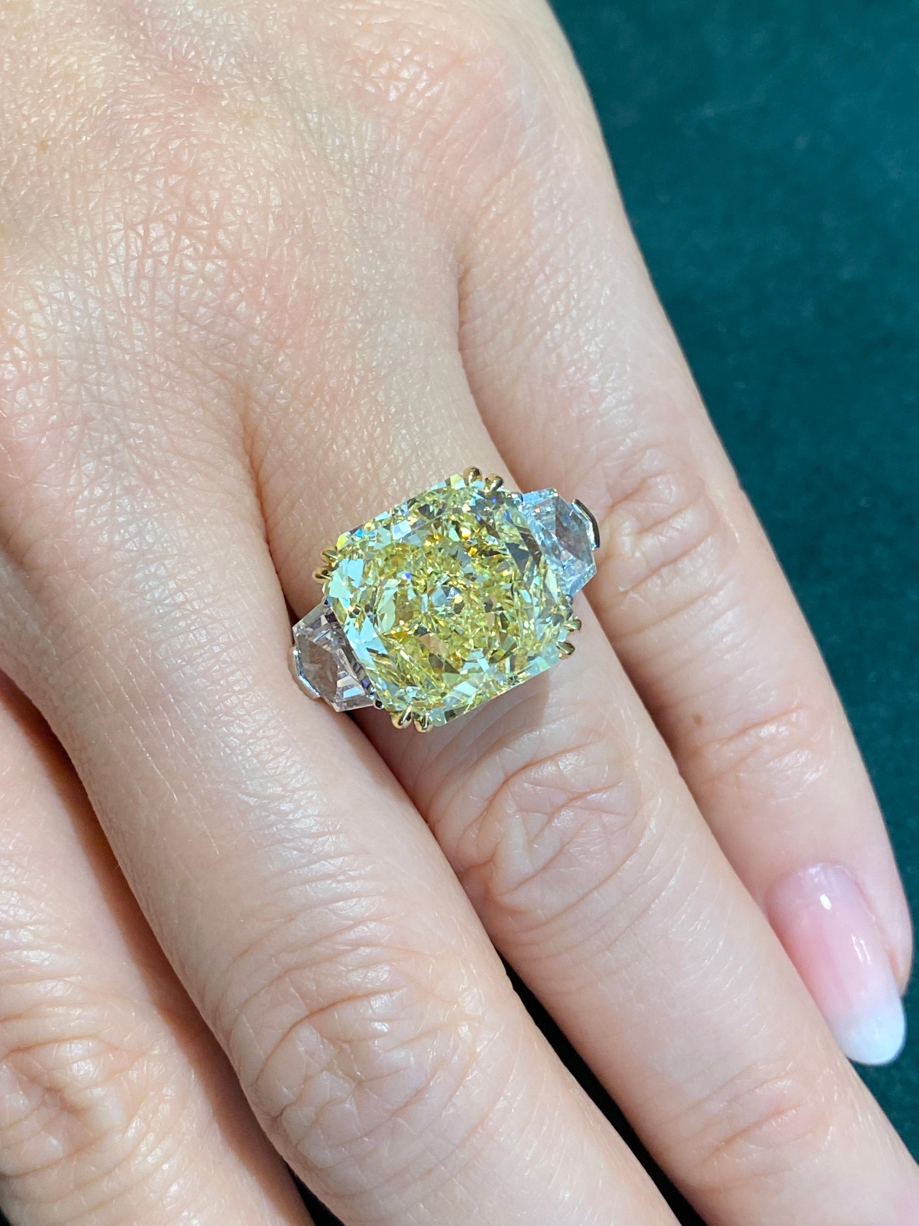 Large Fancy Yellow Diamond Ring in Platinum and 18k Yellow Gold features Center Radiant Cut Diamond
weighing 10.69 carats Fancy Yellow color, VVS2 clarity, GIA certified.
The center diamond is flanked by two shield cut Diamonds weighing 2.11 carats