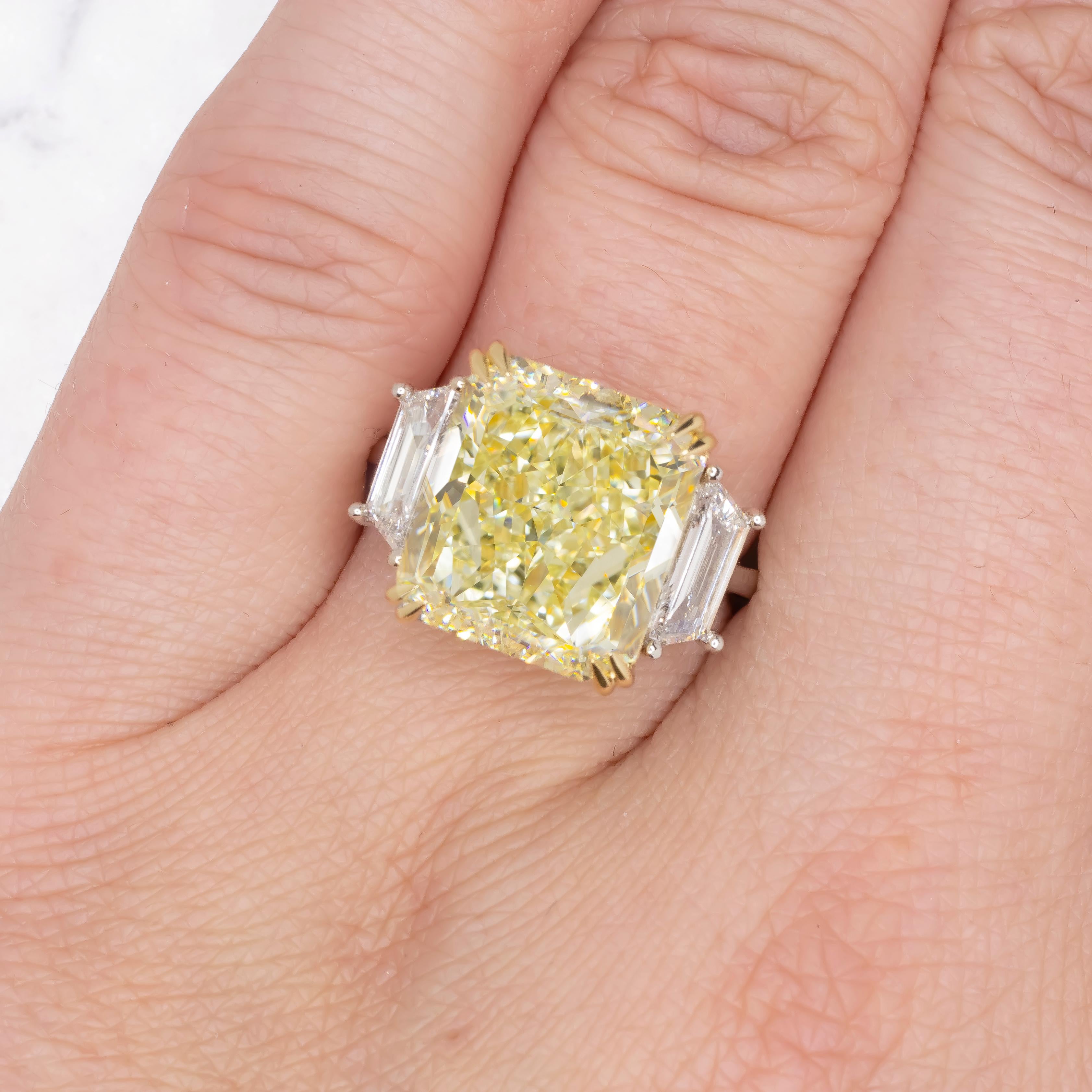 This platinum and 18 carats yellow gold engagement ring showcases a gorgeous 10 carat radiant cut diamond set in a 4 prong 18 karat yellow gold basket. GIA certified the center diamond as Fancy Light Yellow color,  VS2 clarity. Flanking the center