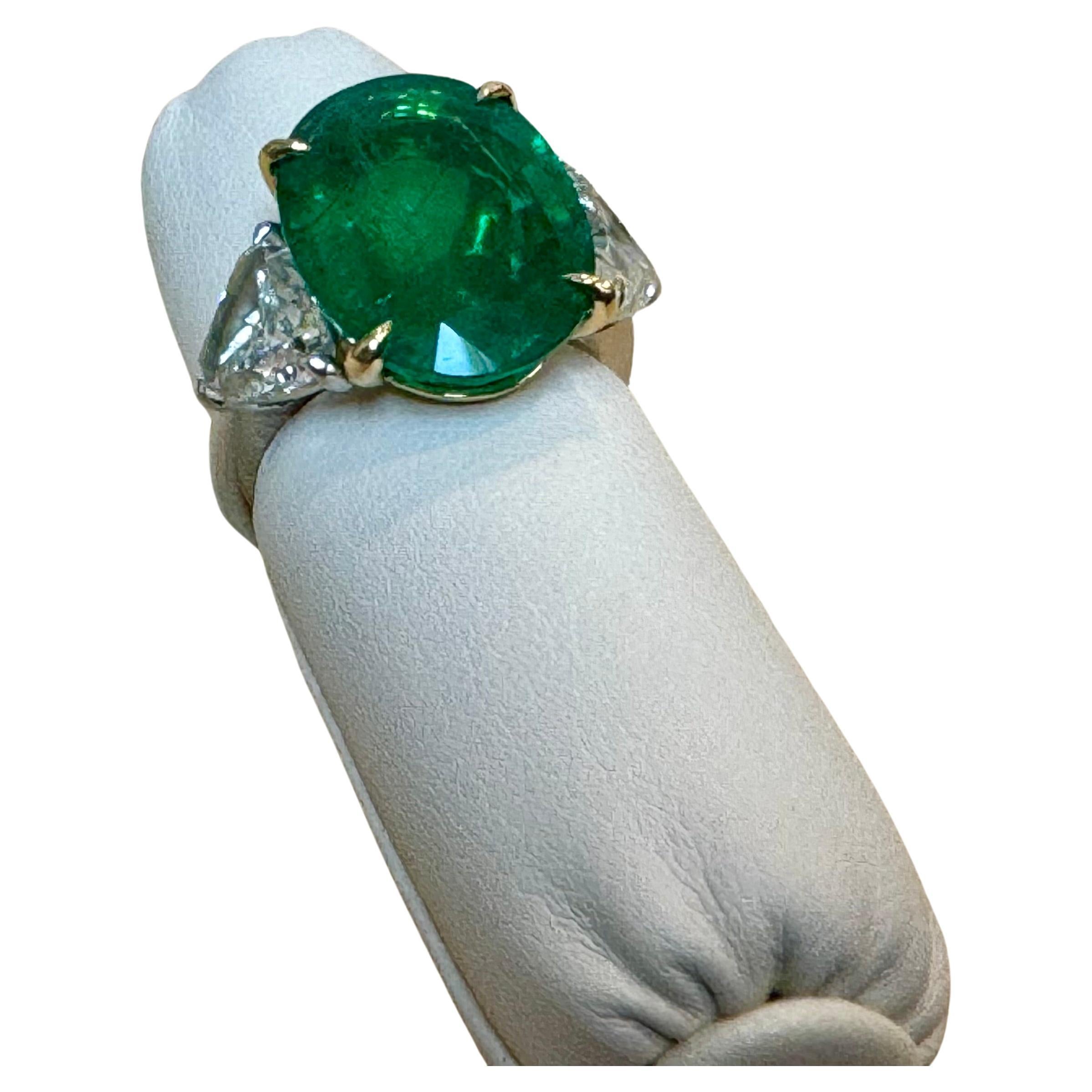 
A classic, cocktail  / Engagement ring 
GIA Certified 11 Ct Fine Oval Zambian Emerald & GIA Certified  1.52 Ct Each Trillion Diamond Ring in Ptatinum and 14 Karat Yellow Gold
Three GIA certificate for three stones in the ring
GIA Report #