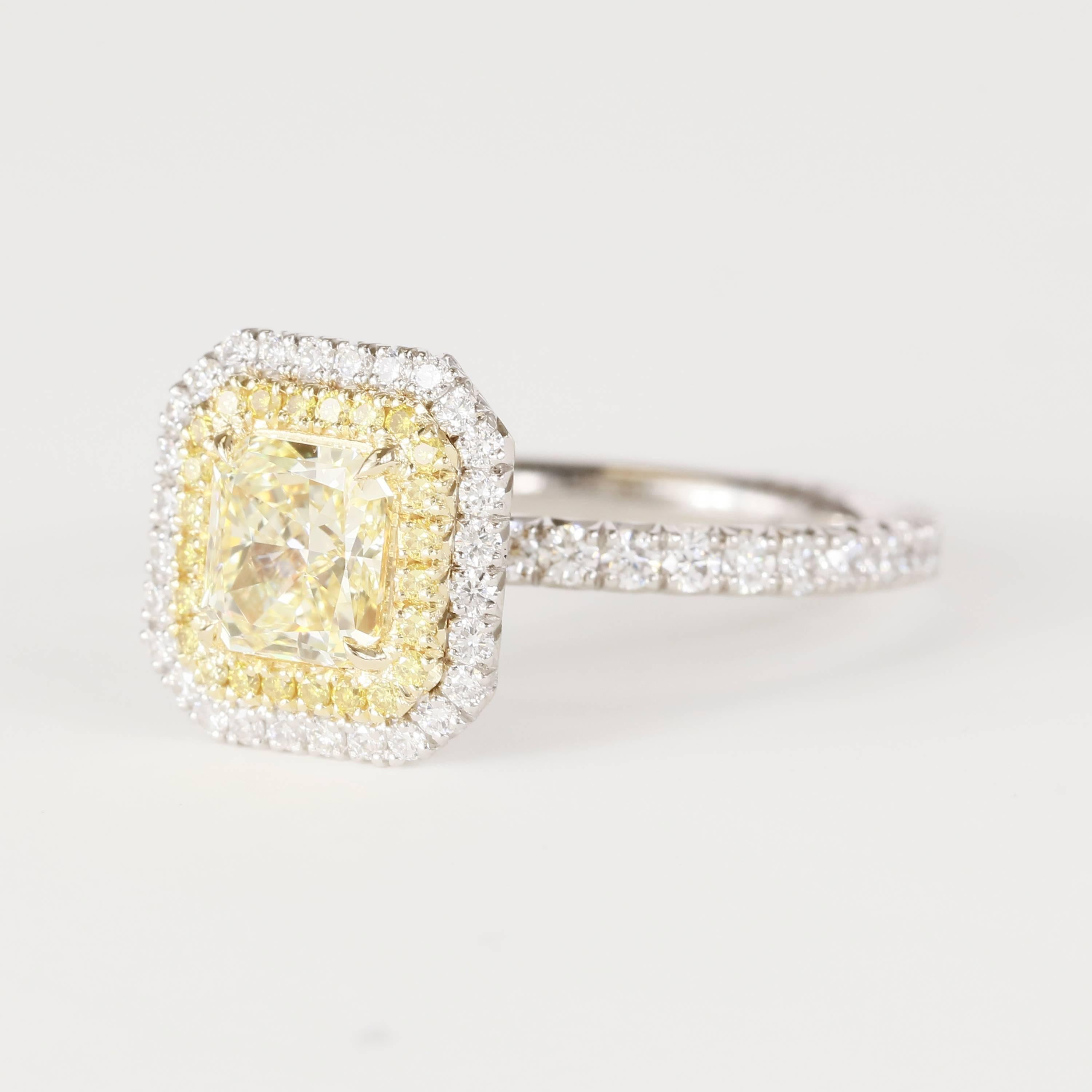 Center stone is a 1.11 carat fancy yellow VVS2 GIA Radiant Diamond
Set in Platinum and 18k yellow gold with a double halo of diamonds
The first halo has fancy yellow melee, 0.18 tw (40 stones)
The second halo (and band) has white diamonds, 0.72 tw