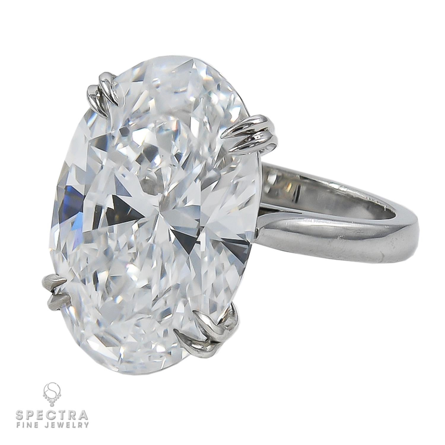 Indulge in the timeless elegance of this exquisite engagement ring crafted by Spectra Fine Jewelry. A captivating centerpiece adorns this piece—a magnificent oval-shaped diamond boasting remarkable specifications: D color, VVS1 clarity, and an
