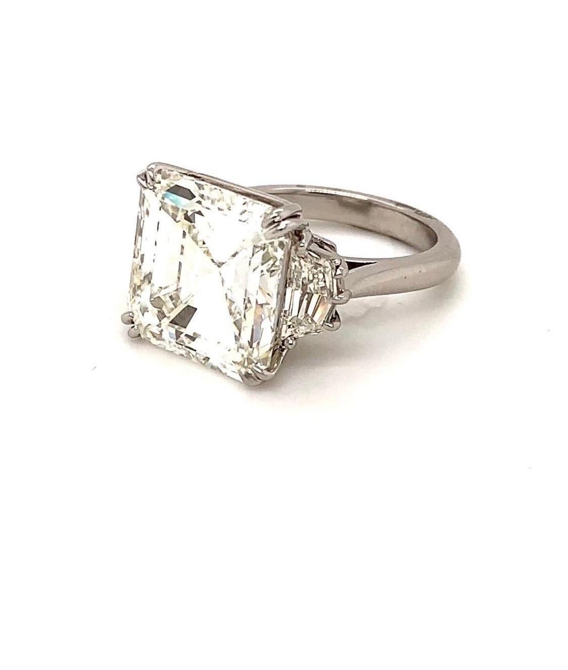 This magnificent GIA Certified 15 carat asscher cut diamond engagement ring is as full of life and luster as a gemstone can get. Mounted in a handmade platinum setting with two side stones, this ring is simply extraordinary. The diamond is graded I
