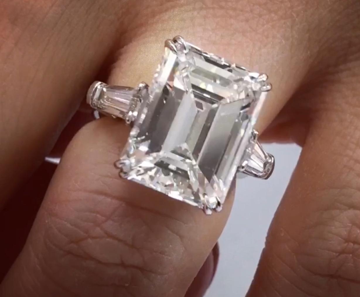 Platinum Three stone Emerald cut Diamond Ring.
The center stone is 11.34 Carats H Color VS1 in Clarity Emerald Cut, set with 1.38 Carats of Baguettes on each side. In Platinum 