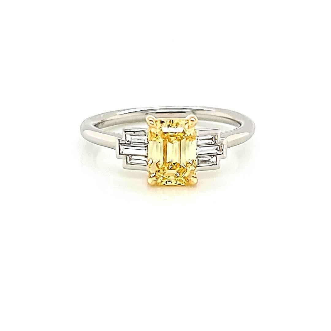 Make a bold and elegant statement with this exquisite handmade platinum ring. At its center lies a remarkable Fancy Vivid Yellow Emerald Cut Diamond, certified by GIA with the reference number 16796874. With its vivid yellow color and impressive
