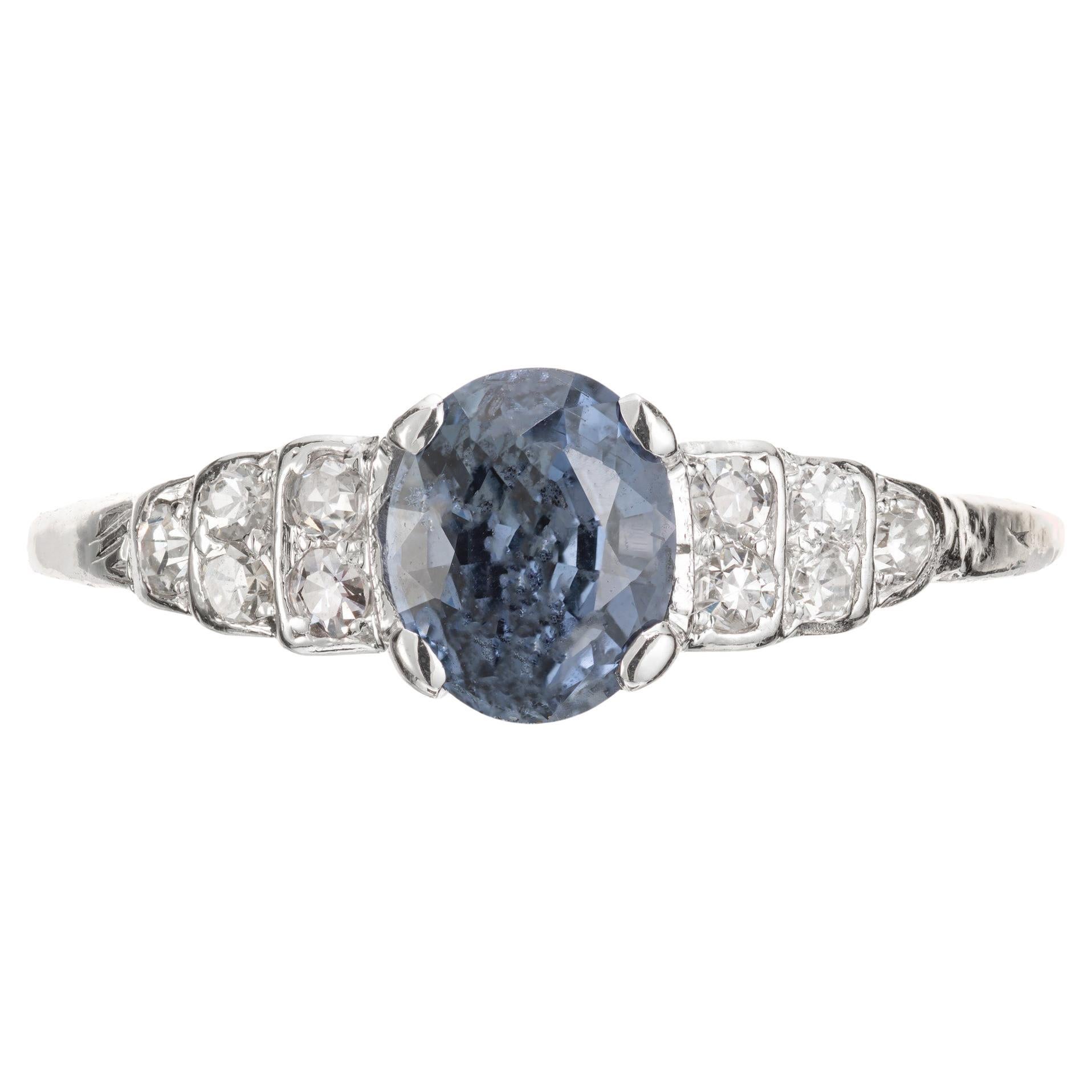 Vintage 1950's estate natural blue oval sapphire and diamond engagement ring. GIA certified sapphire center stone. Natural color with a hint of periwinkle, simple heat only in a platinum setting with 10 single cut accent diamonds.  

1 oval blue SI