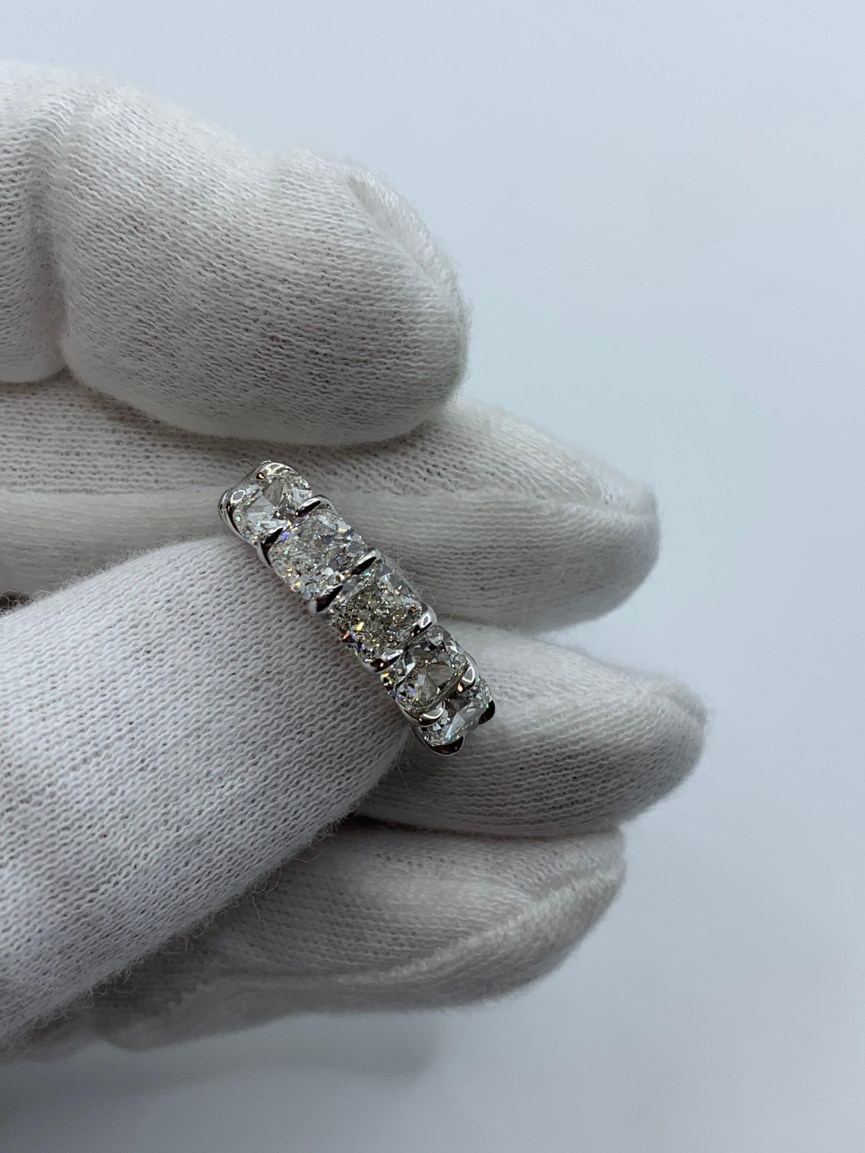 Questa bellissima fascia per l'eternità è incastonata con 13 diamanti taglio cuscino perfettamente abbinati, ciascuno del peso di 0,90 carati per un totale di 11,70 carati. Ogni pietra è certificata da GIA come colore DEF e purezza VVS-VS.