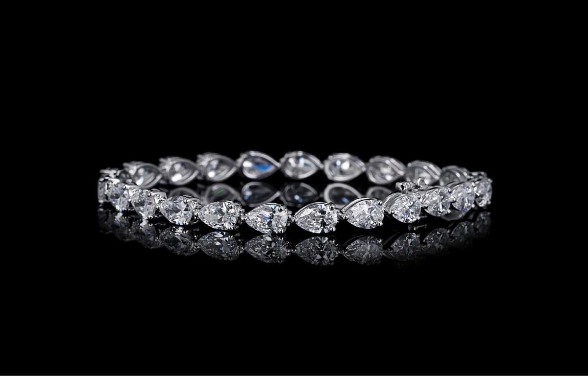 Pear Shape Diamond Tennis Bracelet set in 14K White Gold. This 14K White tennis bracelet has twenty-three pear shape diamonds GIA certified in D-E-F color, VS2+ clarity with a total weight of 11.59 carats.

