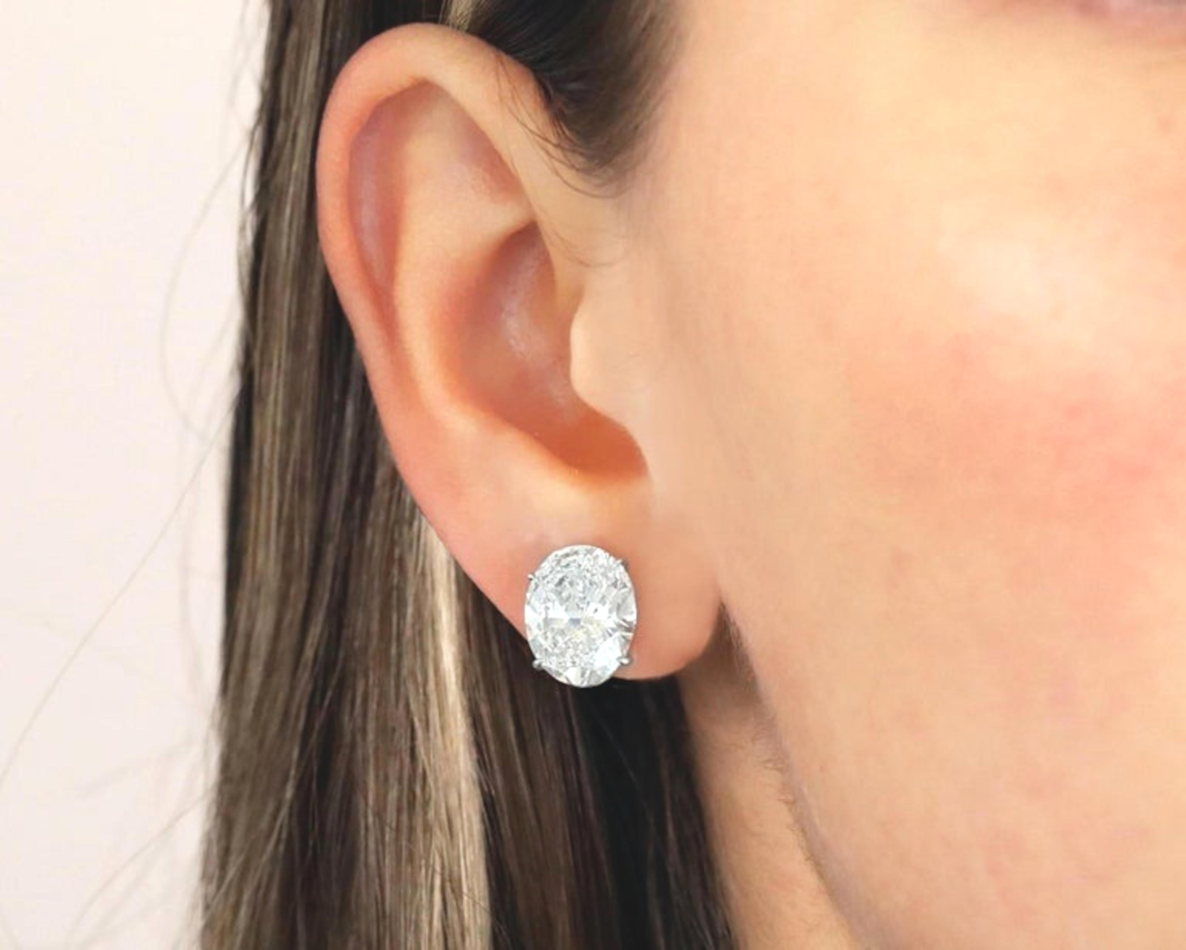 11.83 ct. Oval Brilliant Cut Diamonds Solitaire Pierce Omega Earrings are a stunning set crafted in 18K white gold. The earrings weigh a total of 6.9 grams and each features a remarkable natural oval brilliant cut diamond.

The first diamond weighs
