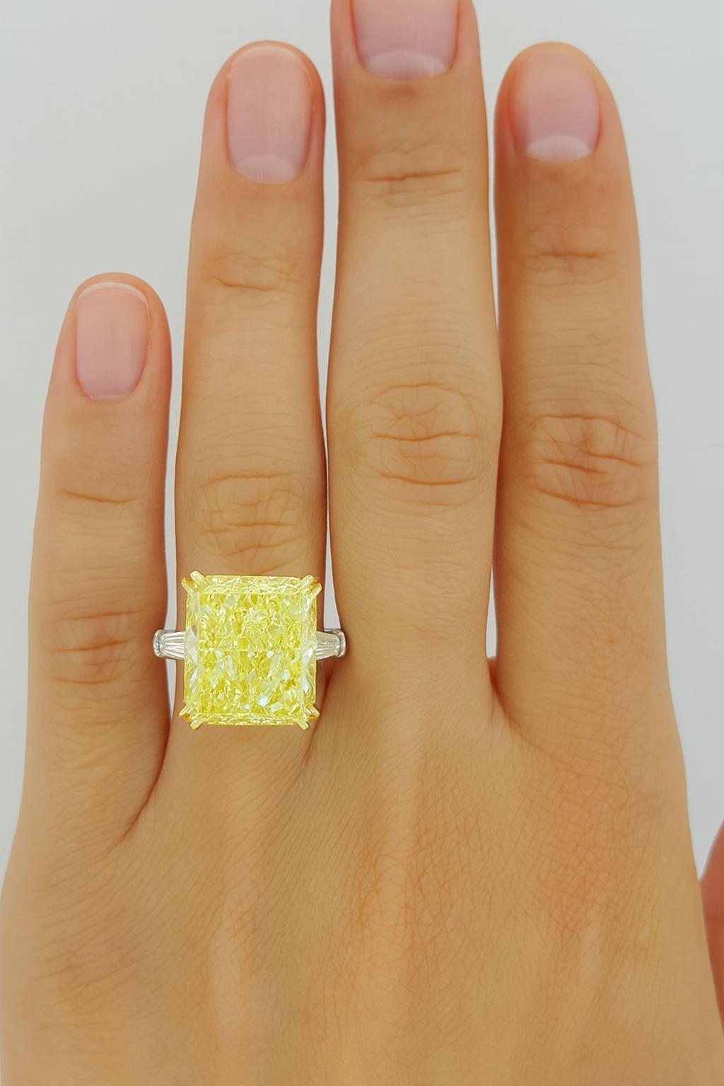  Rectangular Radiant Cut diamond weighing 12 ct, with a Fancy Intense Yellow color, IF clarity.
Accompanying the center stone are two Natural Tapered Baguette Cut side diamonds weighing a total of 0.65 ct, with E-F color and VS1-VS2 clarity.

The