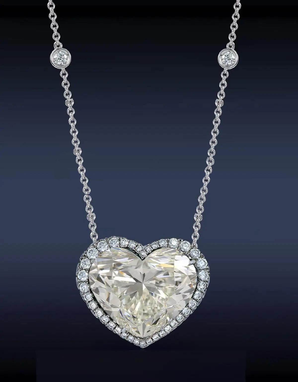 This diamond pendant necklace showcases a superb 10.02  heart shaped center diamond, GIA certified. 

It is surrounded by a halo of round brilliant cut diamonds and the bail is also studded with sparkling diamonds for added brilliance in this