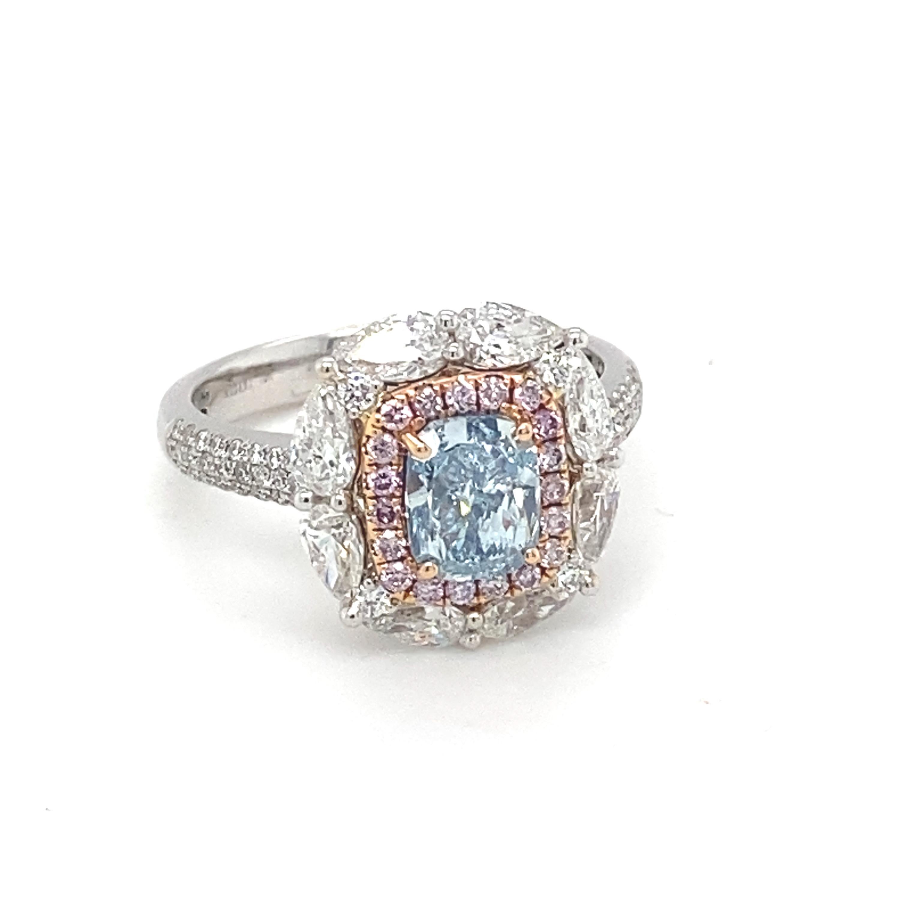 This opulent ring boasts a highly desirable GIA Certified 1.20 Carat cushion shape Natural Blue Diamond is framed by a glittery halo of pink diamond which is surrounded by pear shape diamond. The spectacular radiance of these majestic blue, pink and