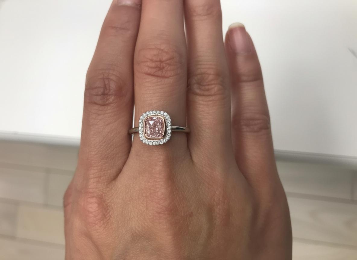 Dieser außergewöhnliche, in New York handgefertigte Ring präsentiert einen GIA-zertifizierten 1,20-karätigen Fancy Orangy Pink-Diamanten im Kissenschliff, eine außerordentlich seltene und begehrte Farbe, die für ihren strahlenden, romantischen