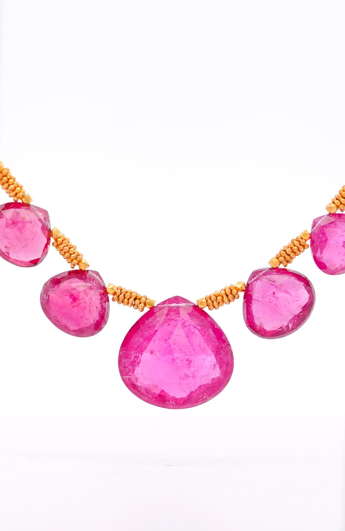 A 22K gold necklace with a 120-carat total assortment of pear-shaped pink checkerboard cut rubellite tourmalines. The gems have wonderful rounded facets that give the necklace texture and contrast. The chain is made of 22k gold and is fixed with an