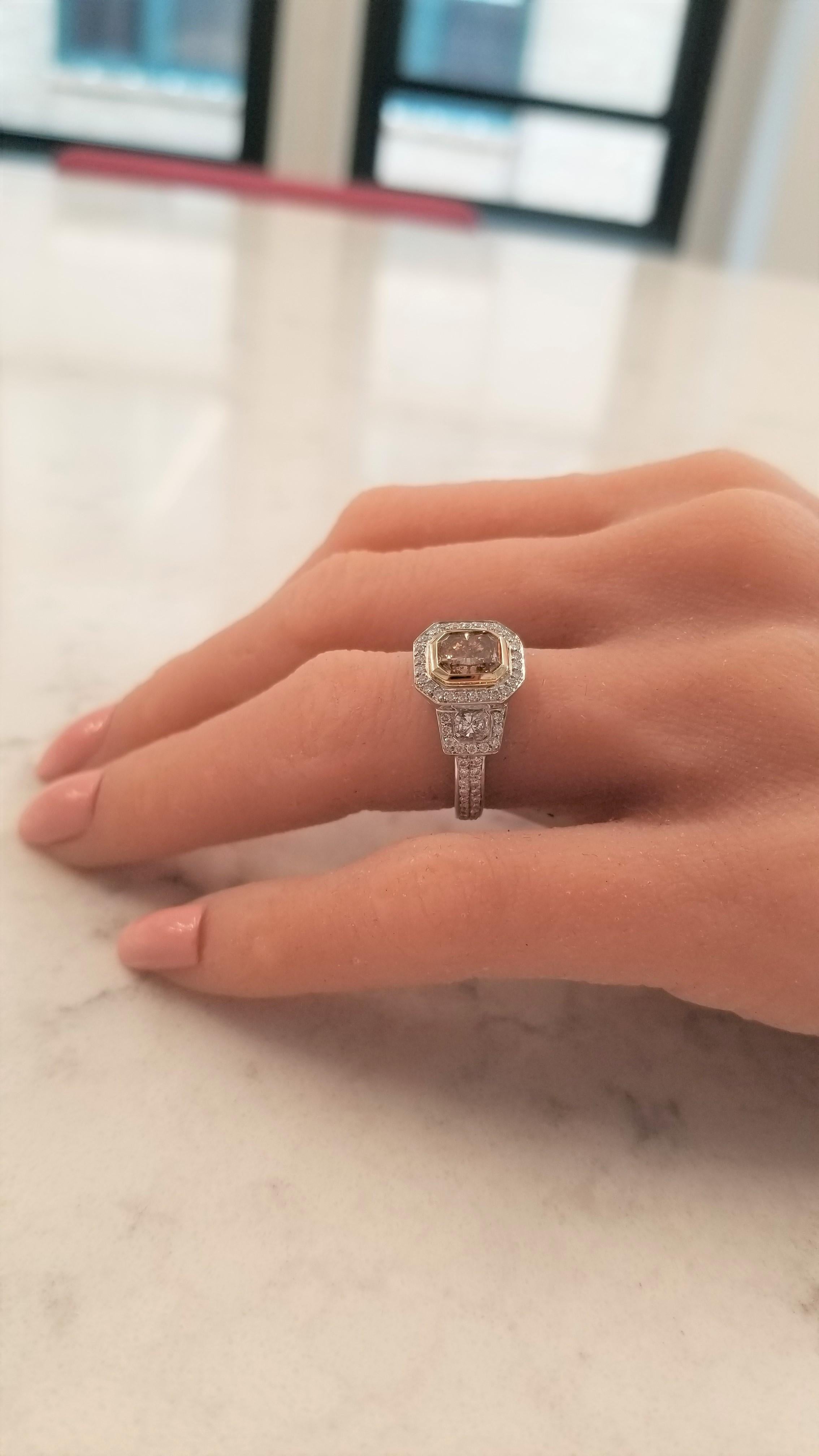 This is an incredible piece of fine jewelry! Platinum and yellow gold are the dynamic duo that make this piece sing. This stunner features a 1.20 carat radiant-cut natural cinnamon diamond center in an 18k yellow gold frame. It is cleverly enhanced